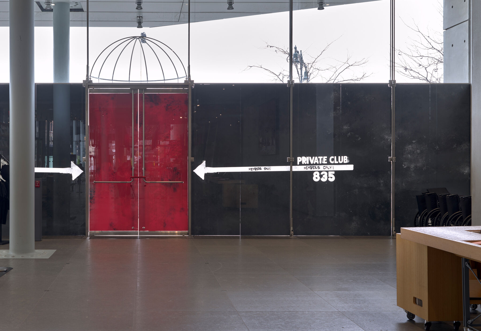A red set of doors against a black backdrop, with white arrows and the words "Private Club 835".