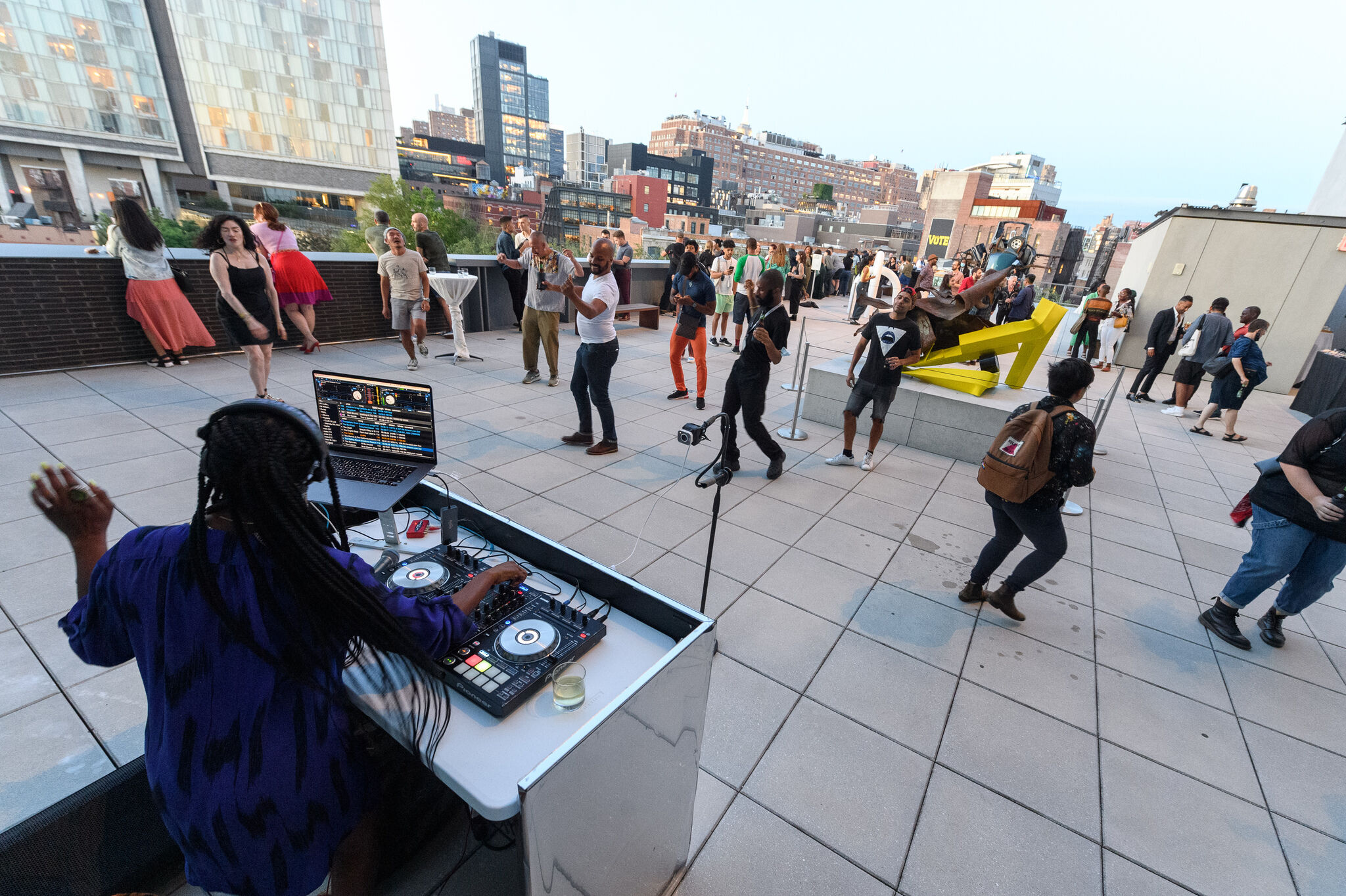 A DJ playing and people dancing on the Whitney terrace. 