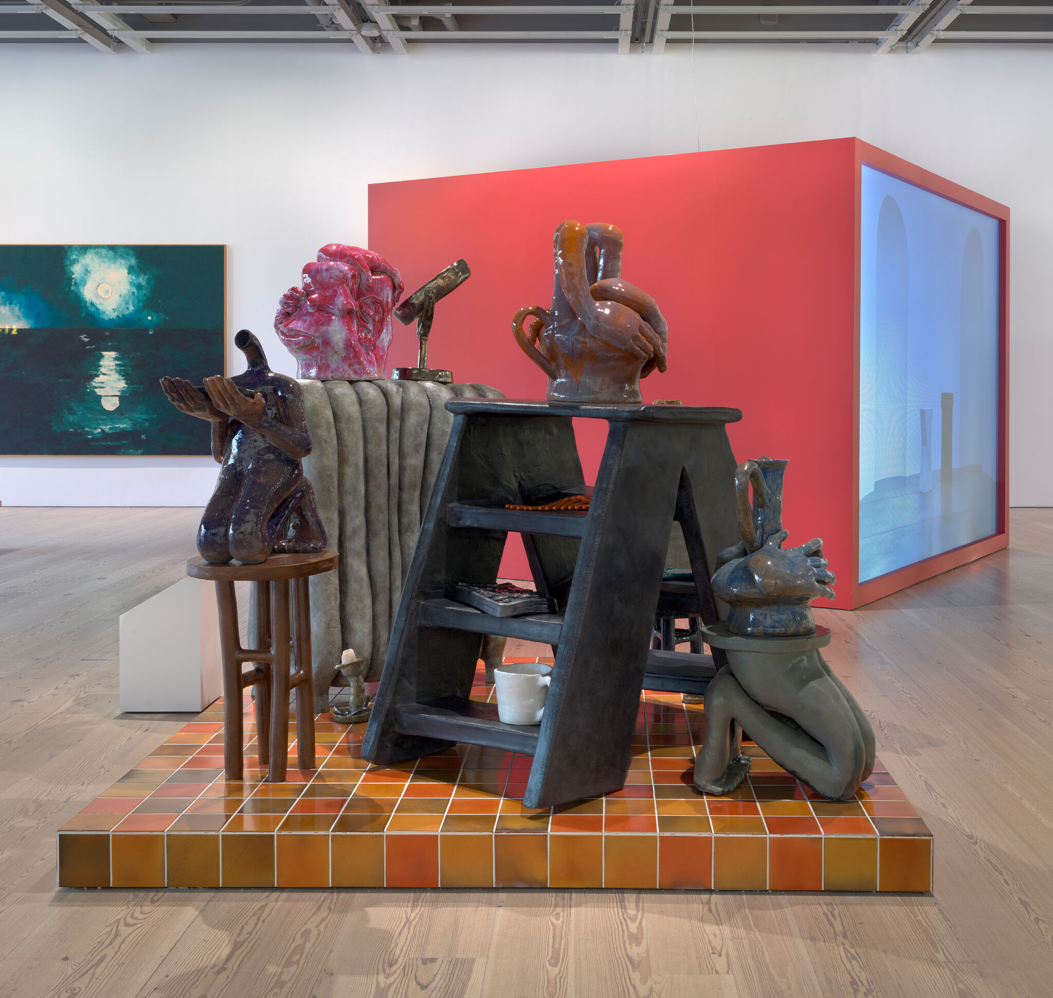 A group of ceramic sculptures arranged in a cluster and elevated on a tiled plinth. 