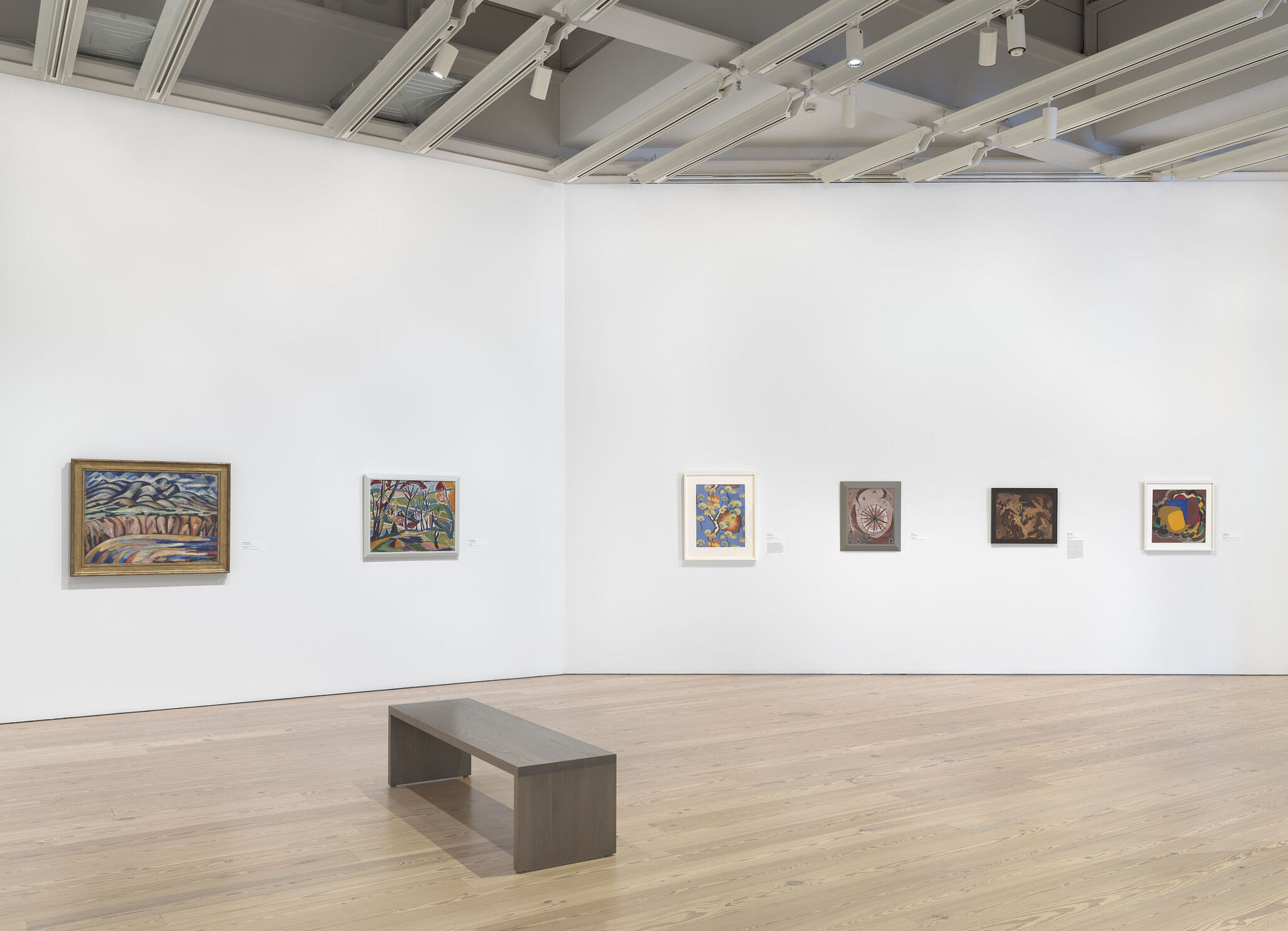 A white exhibition room with six works installed on the outer wall.