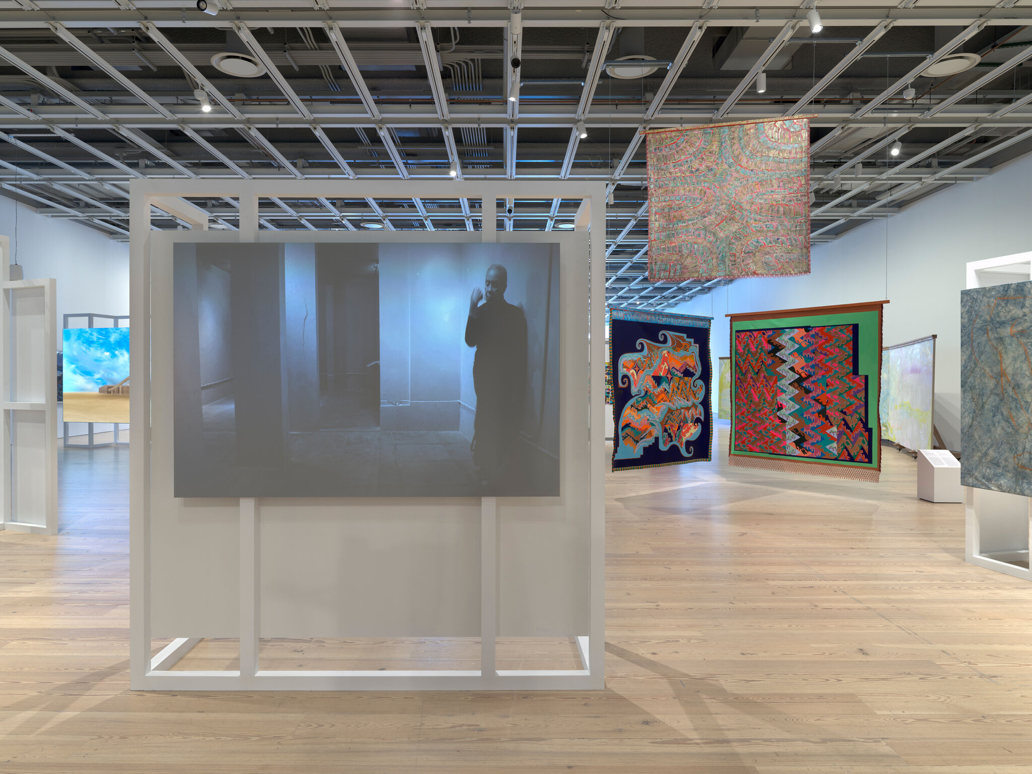 Multiple artworks in a light-filled gallery.