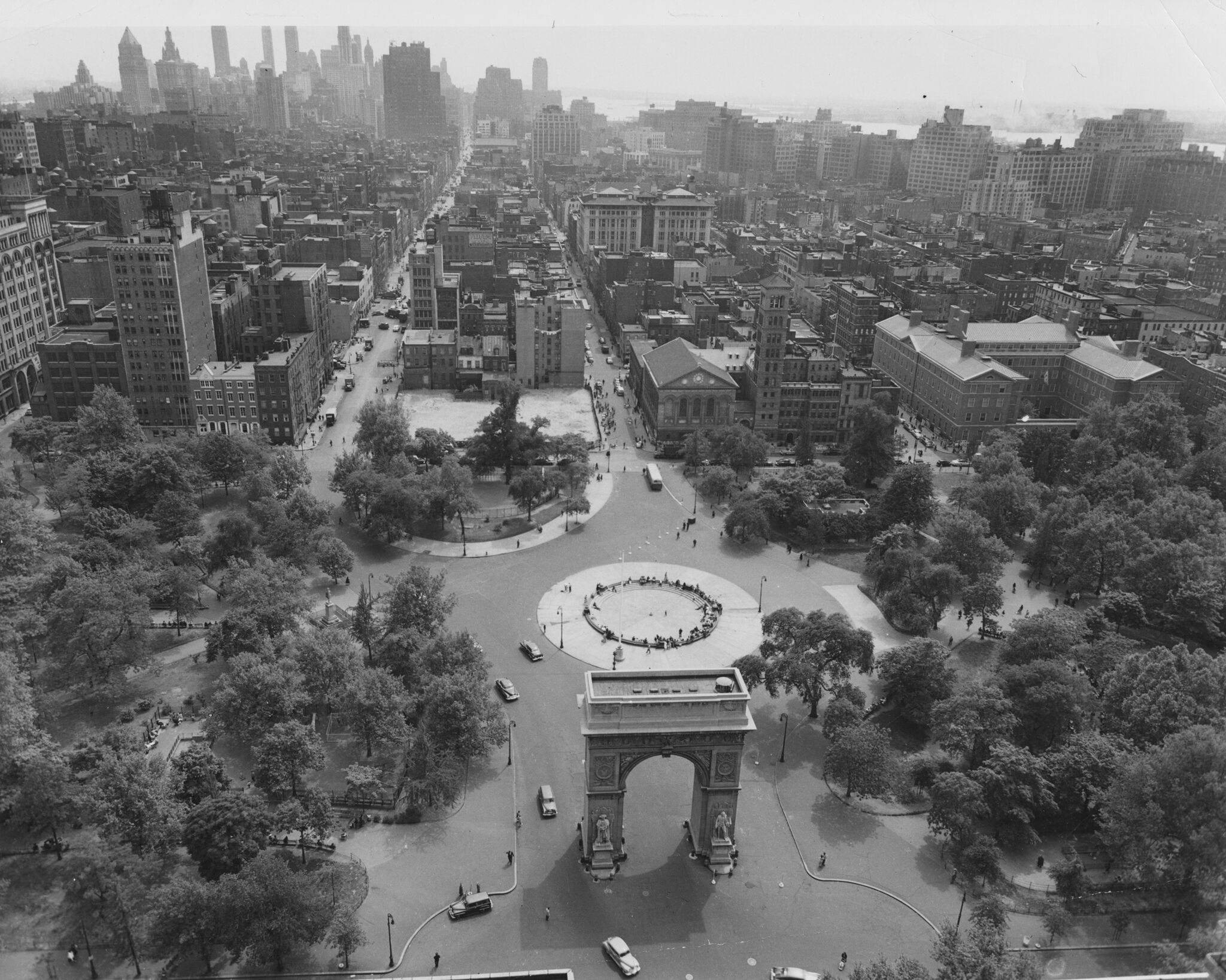 An aerial view of Washington Square Park with a city skyline in the background.