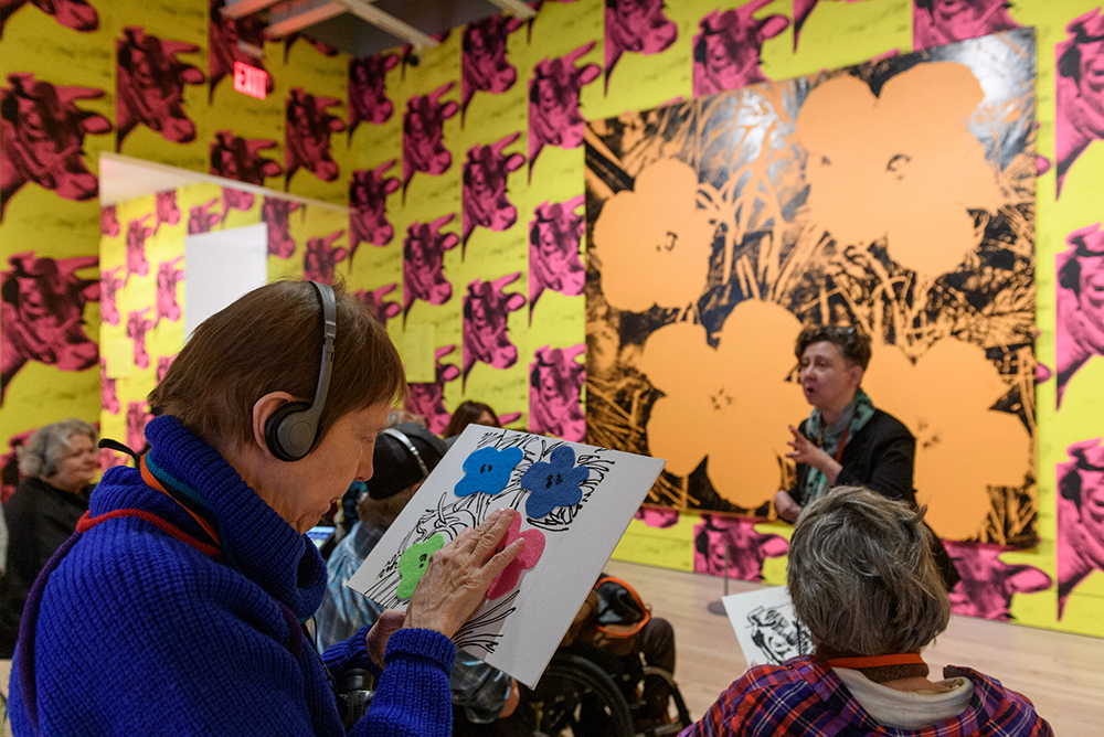 Woman works on an activity in a gallery with brightly colored walls. 