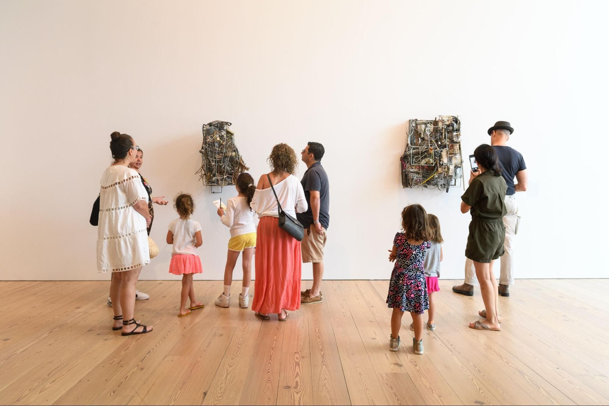 Un grupo de niños y adultos mirando esculturas en las galerías.