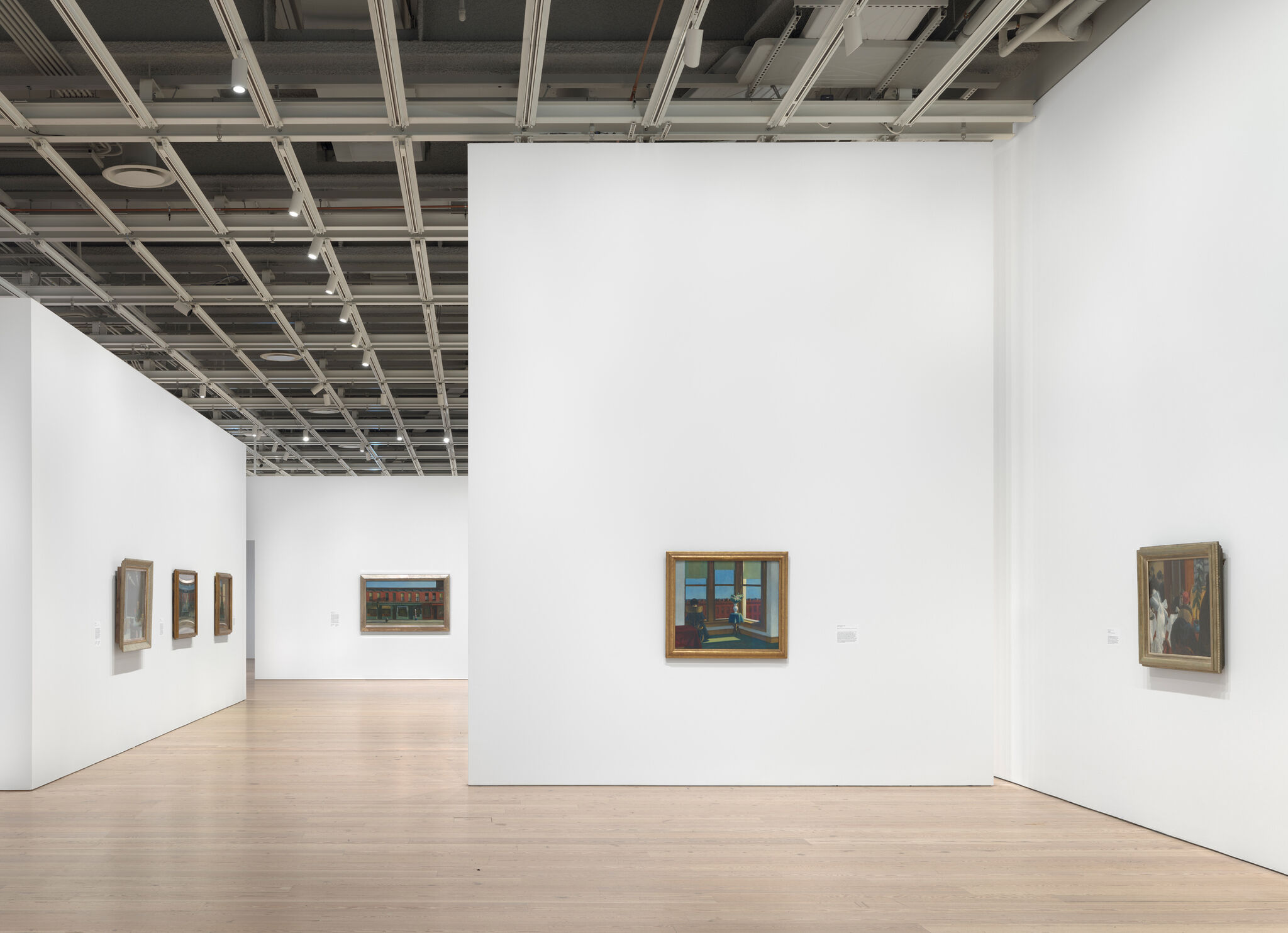 Multiple artworks in a light-filled gallery.