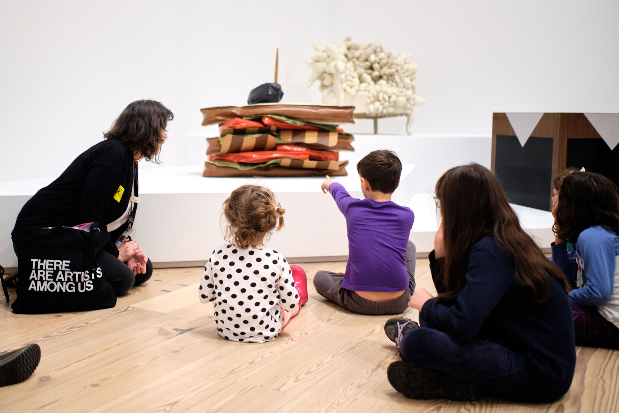 Un grupo de niños y adultos discuten una instalación en las galerías.