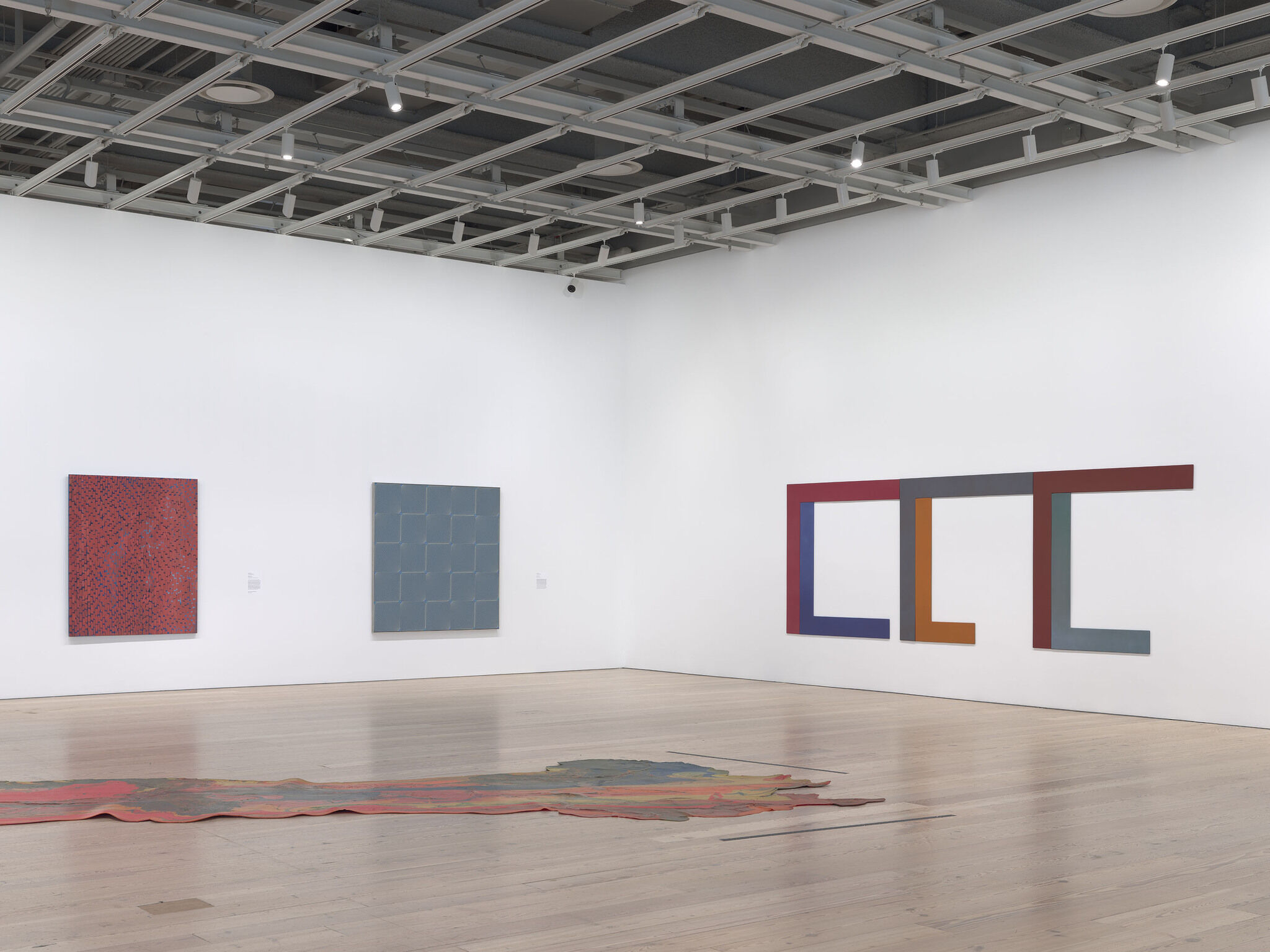 Gallery walls with artwork hung up and sculptures in the center of the space. 