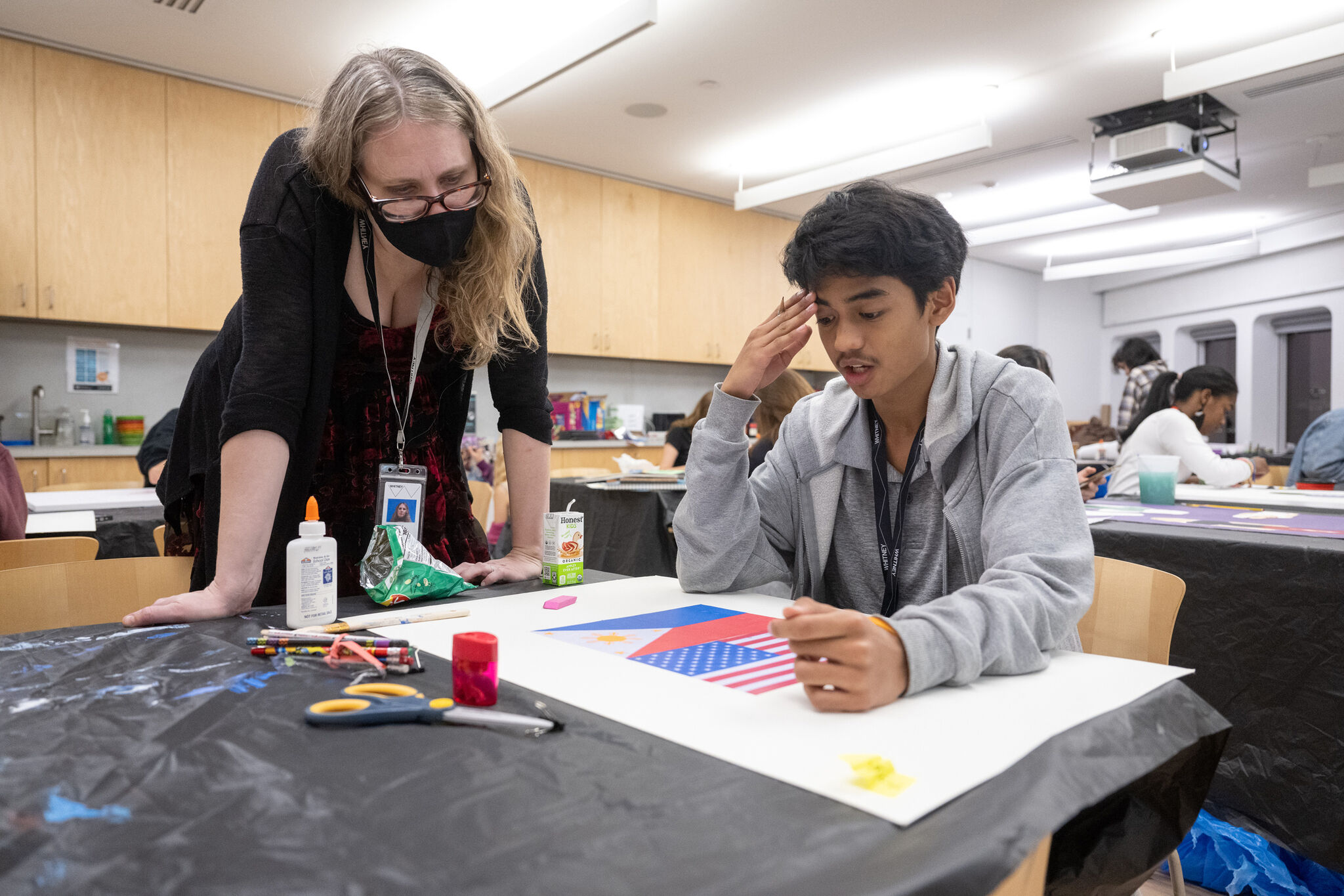 Teen discusses their artwork with educator, Kristin Roeder.