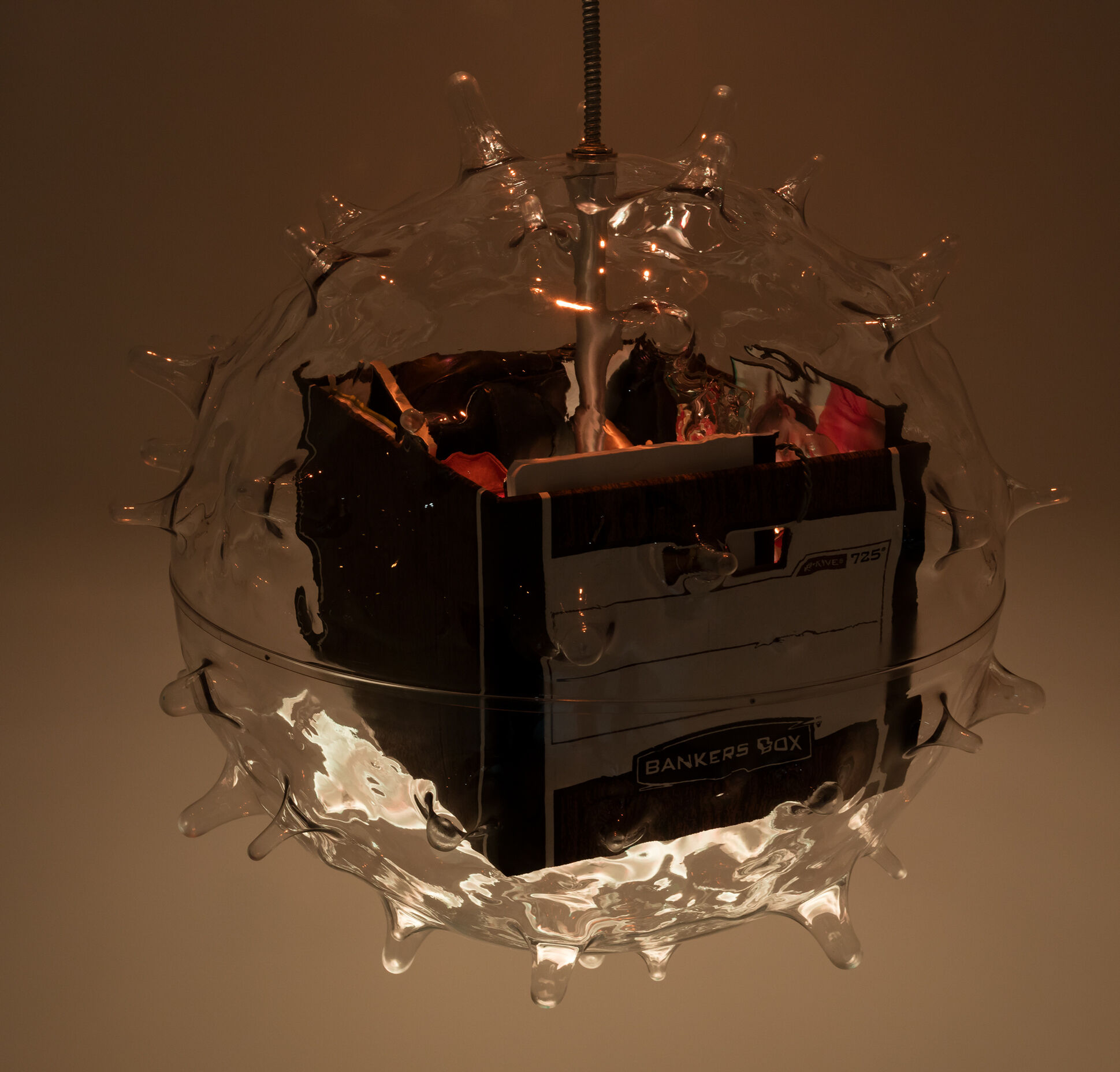 A file box suspended within the transparent shape of a virus. 