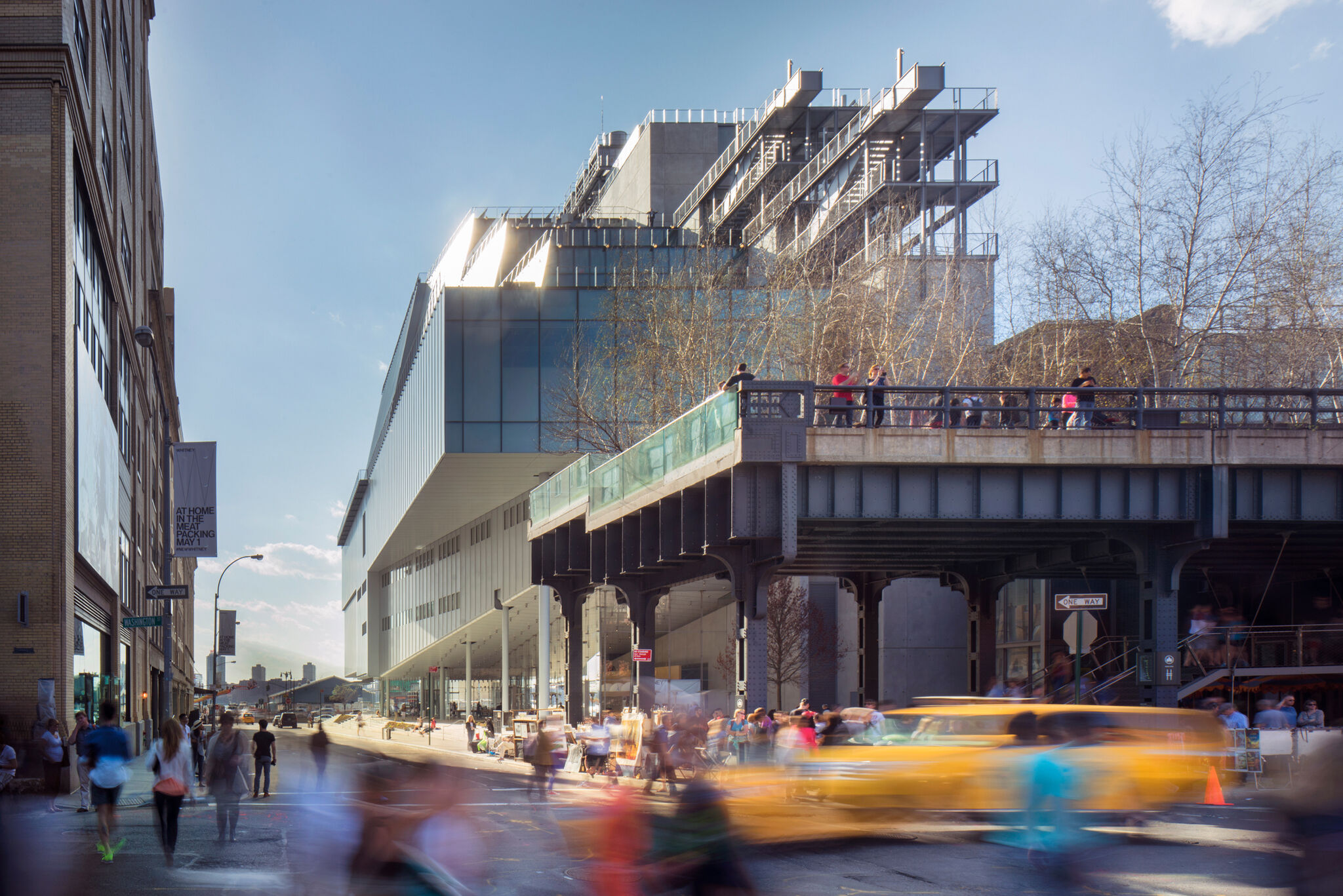 A view of the Museum with people and traffic in the foreground. 