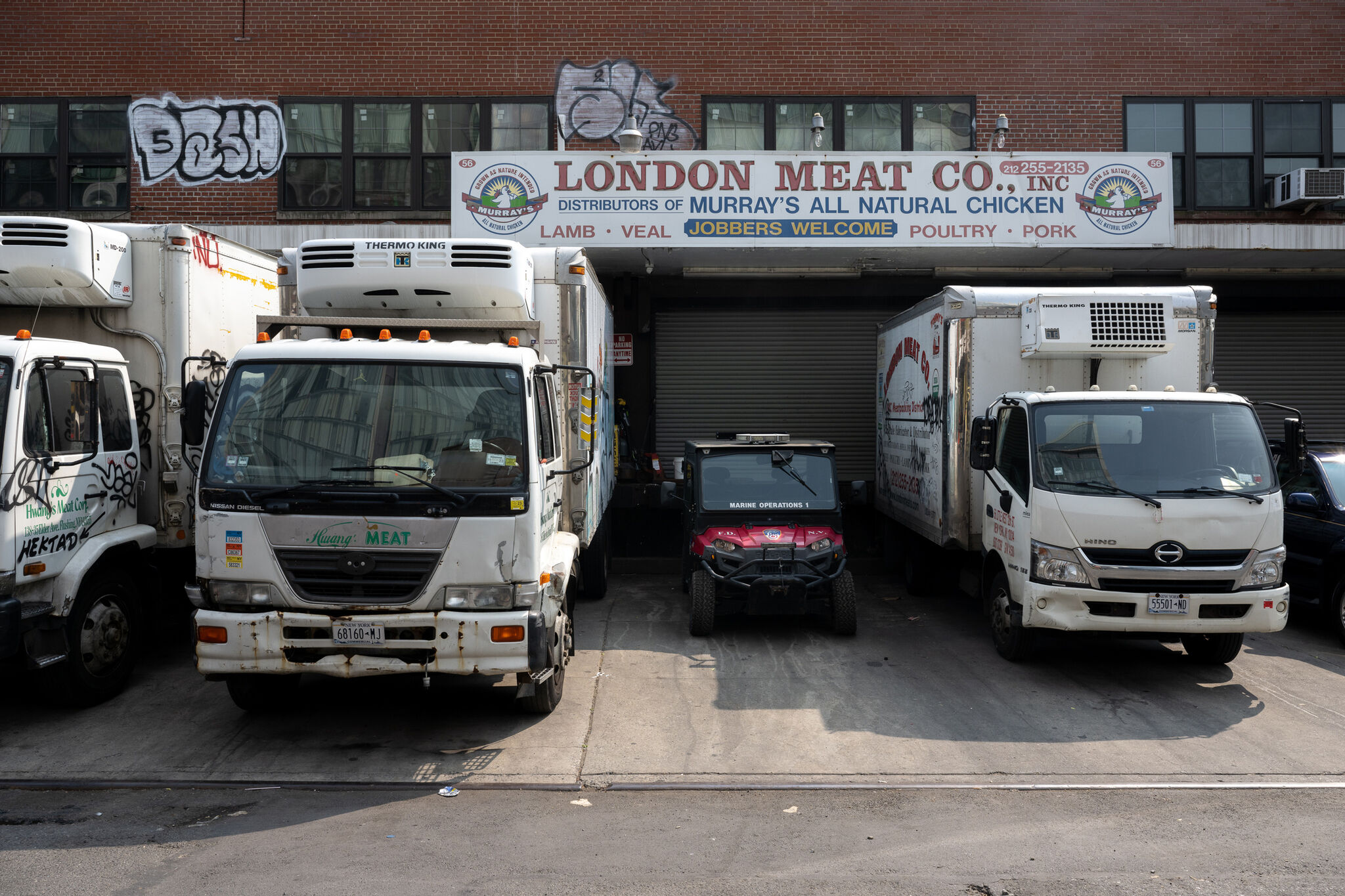 Trucks lined up in front of a brick building.