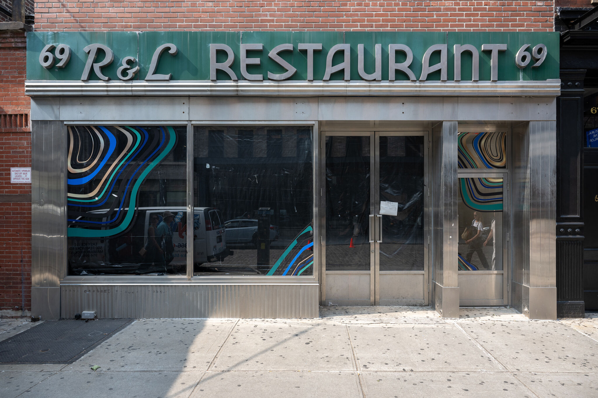 The exterior of a building with the sign "R & L" on the facade. 