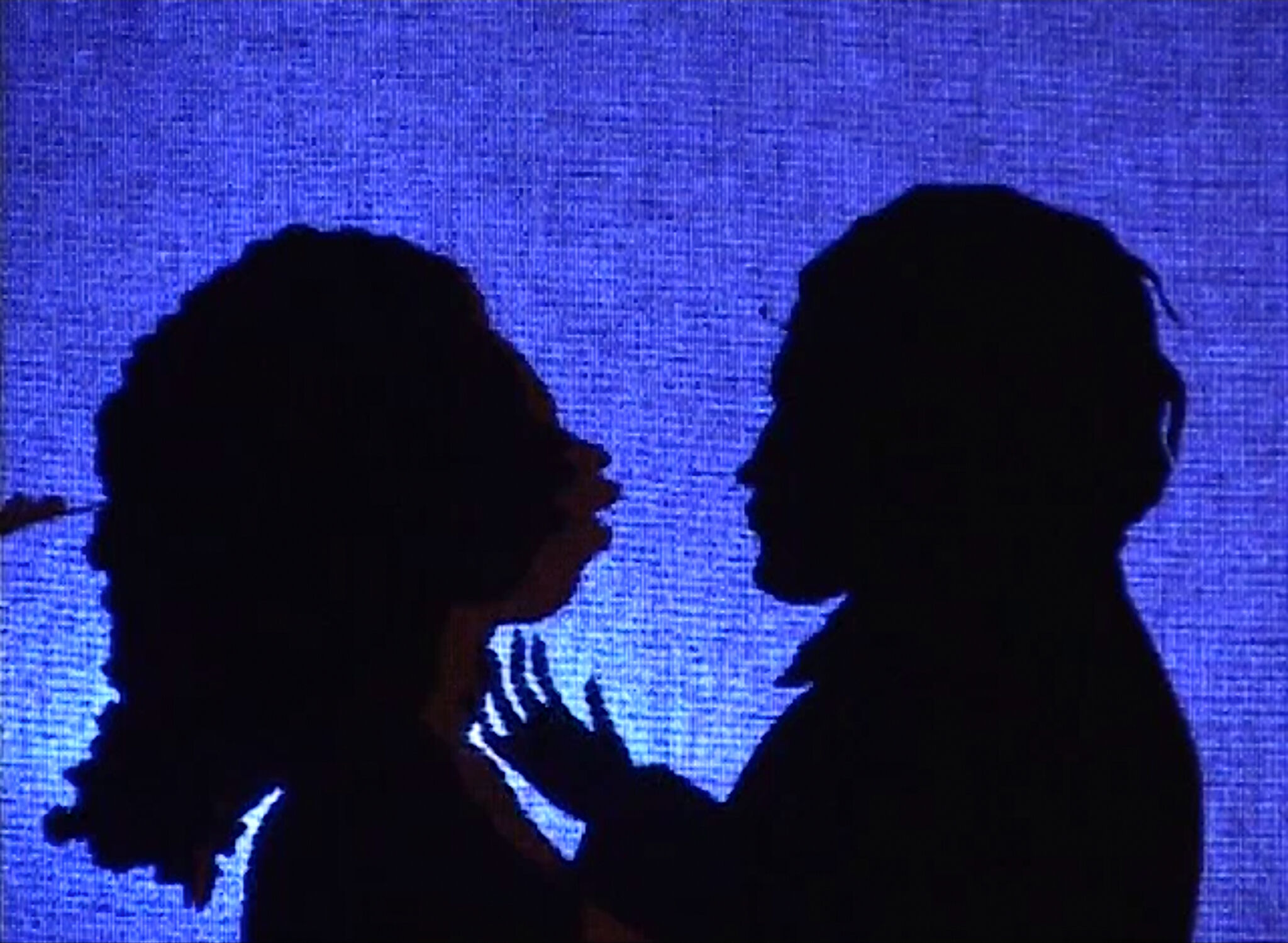 The silhouettes of two people facing each other against a blue background. 