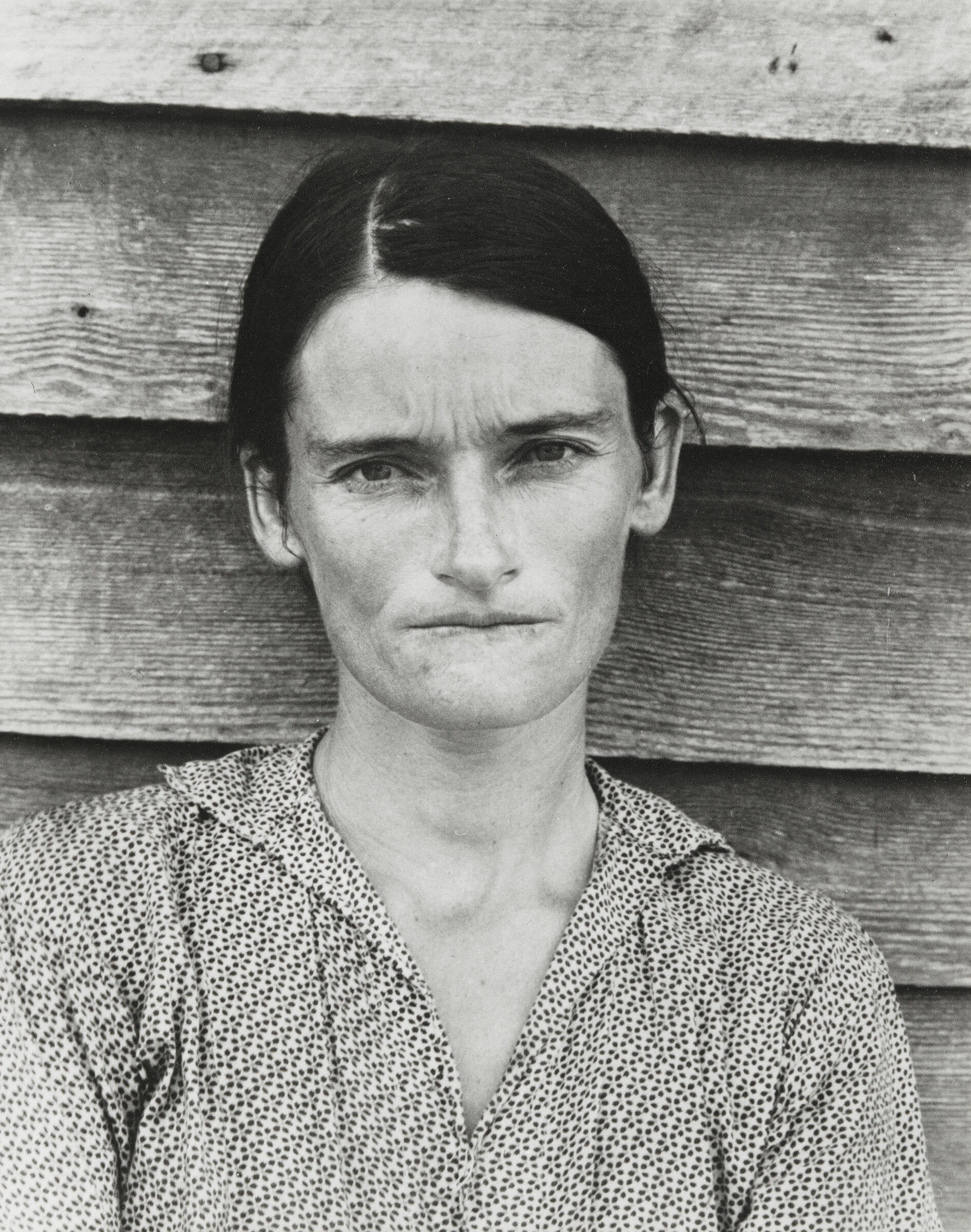 A black and white photograph of a woman looking into the camera.