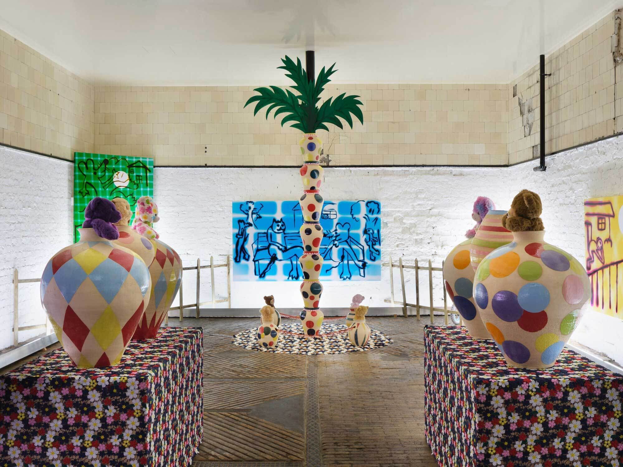 A room with colorful polka dot pots with stuffed animals peeking out, leading to a colorful palm tree stacked of pots.