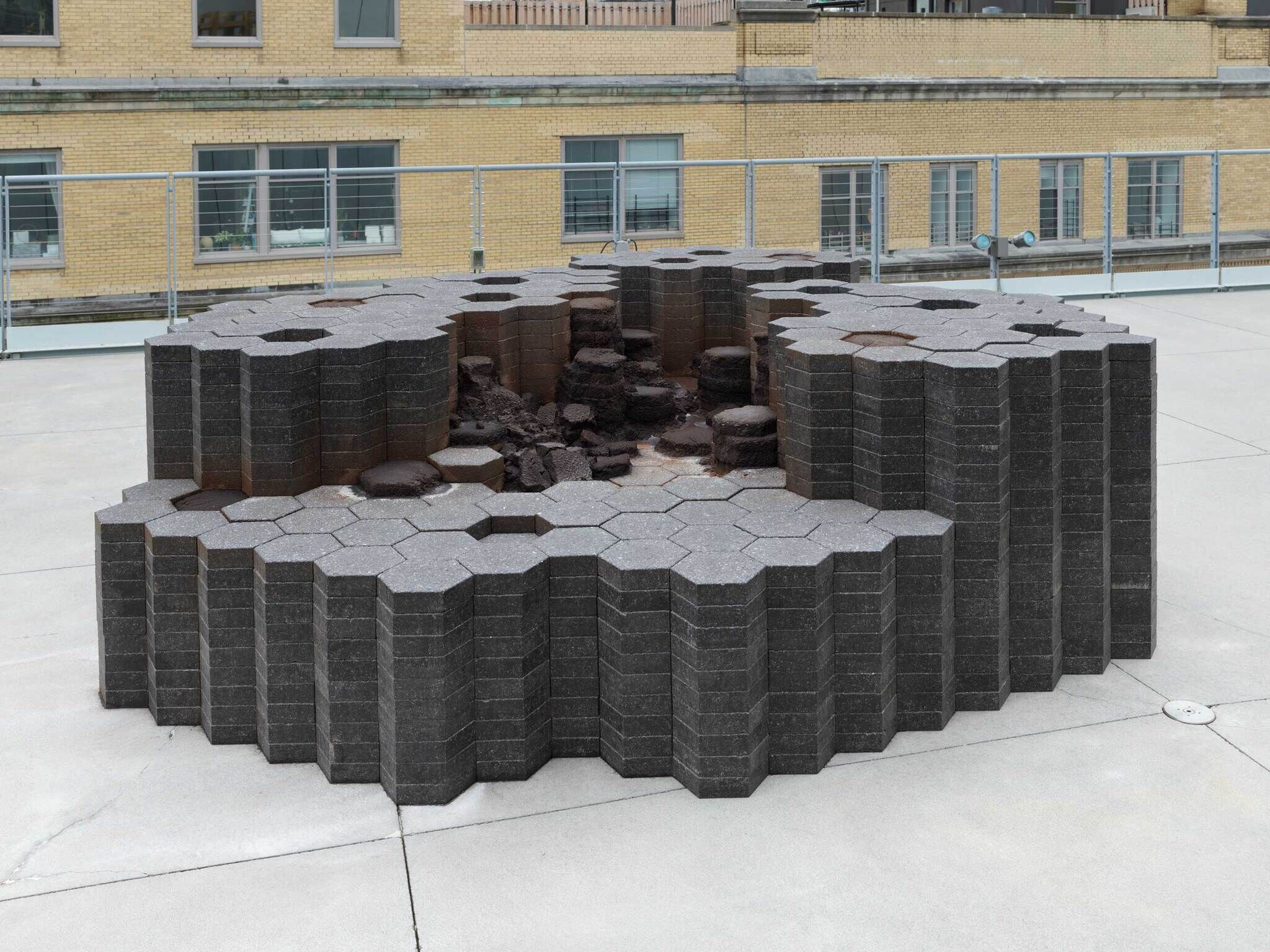 A sculpture made of dark hexagons stacked on top of each other.