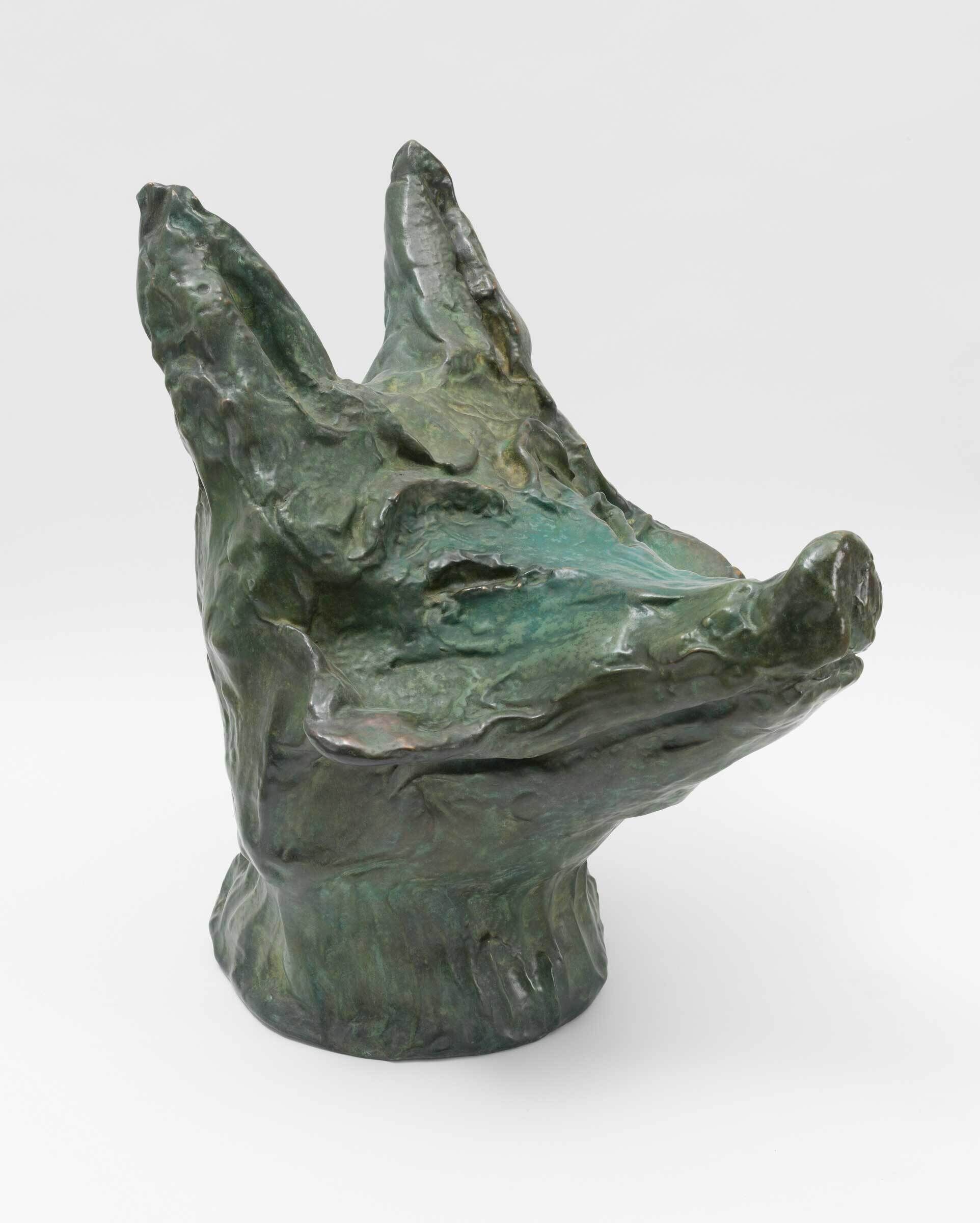 A cast bronze sculpture of a coyote's head.