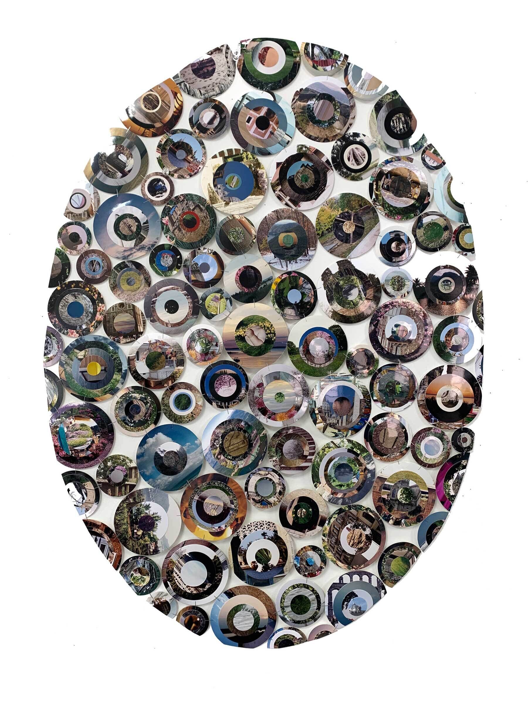 An oval shaped image of multiple circular mirrors clustered together.