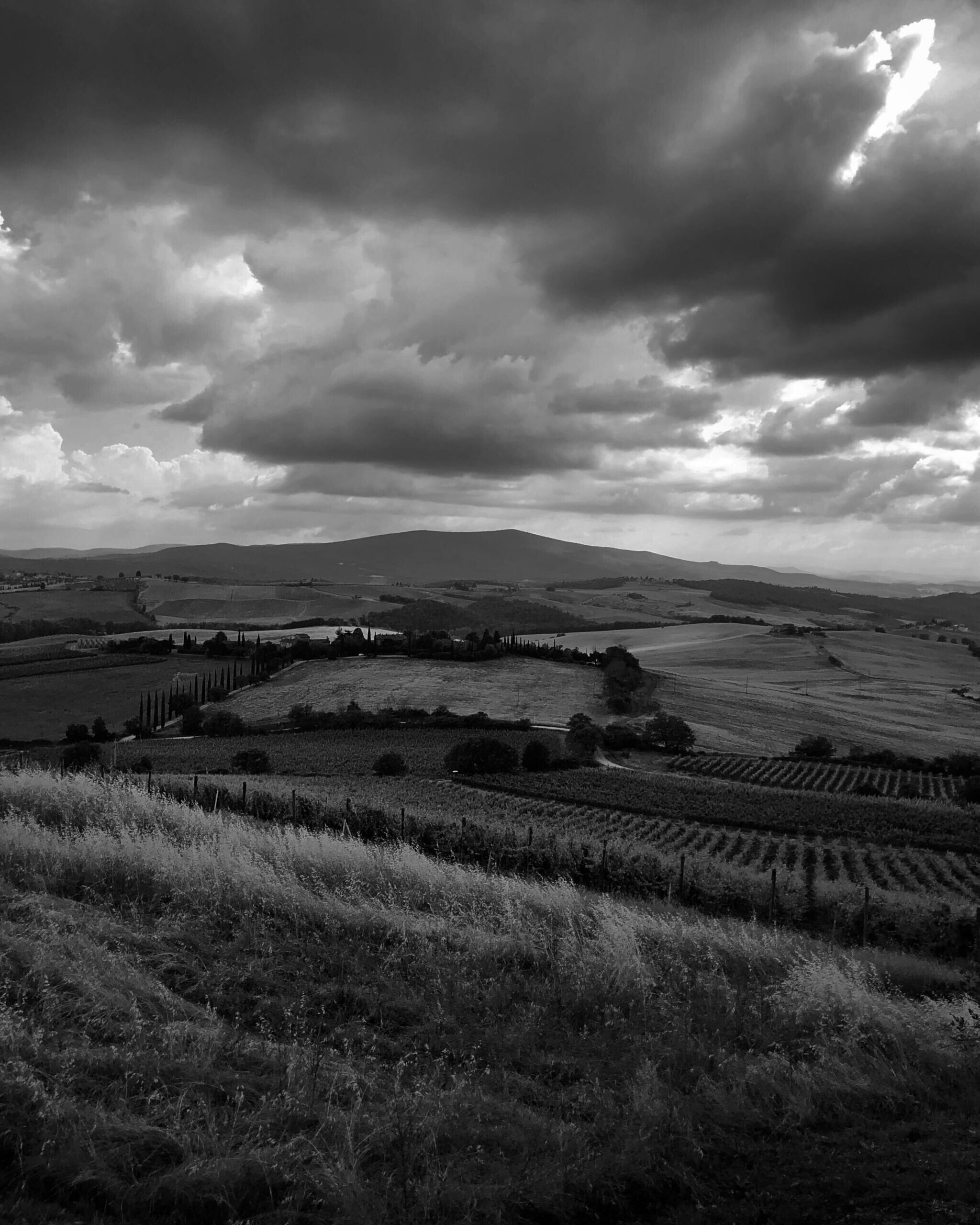 A black and white photograph of the Italian countryside with contrasting clouds.