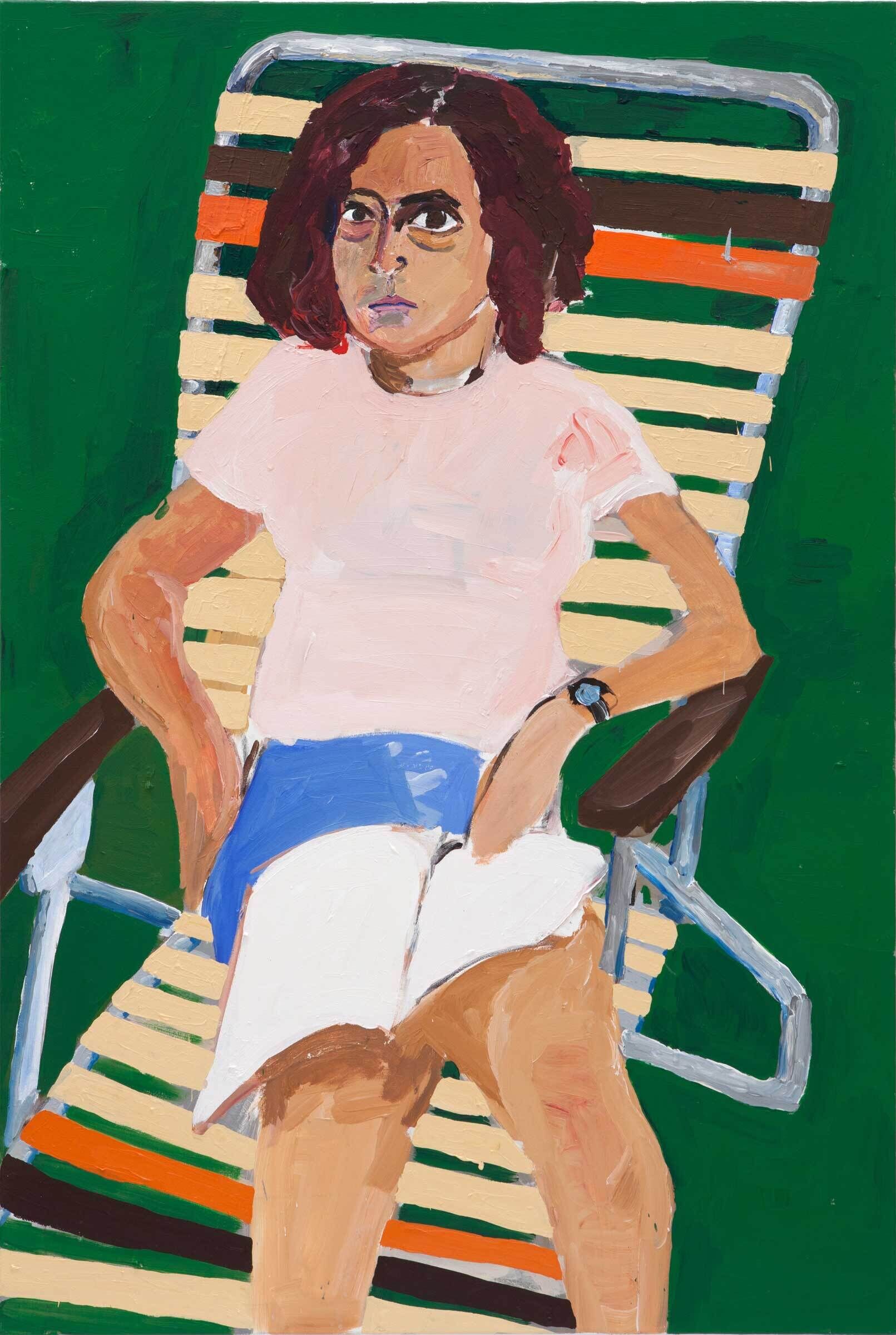 A woman with short, reddish-brown curly hair sits on a deck chair. She wears a light pink t-shirt and blue shorts, and an open book lays on her lap. The background is a grassy green.