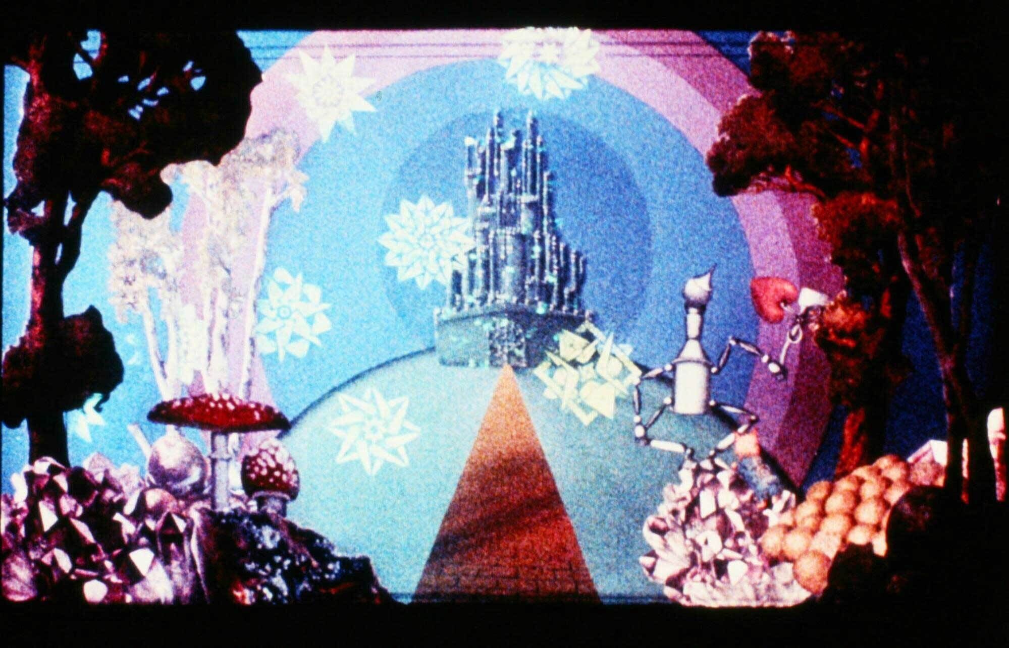 Trees, toadstools, and the figure of the tin man frame the view of a tall castle atop a hill. 