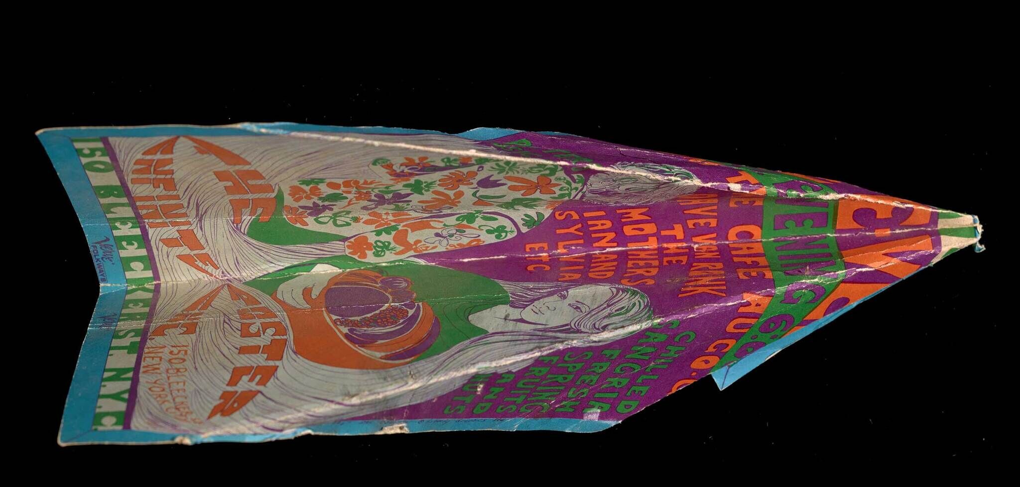 A sheet of white paper with drawings in blue, green, pink, and orange, folded into a paper airplane.