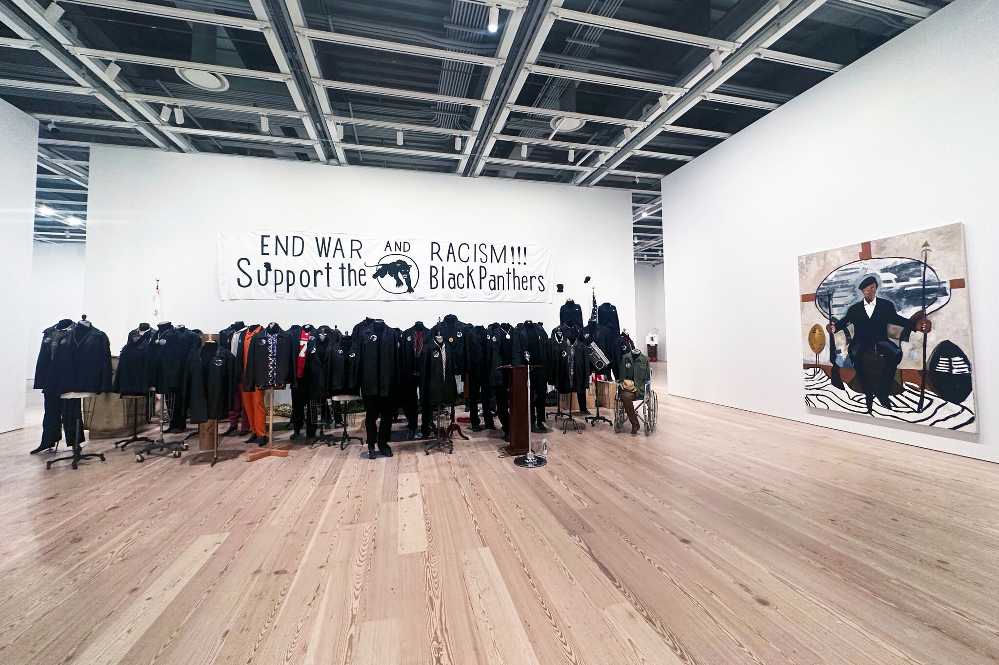 A group of black clothed mannequins and a Black Panthers banner above.  