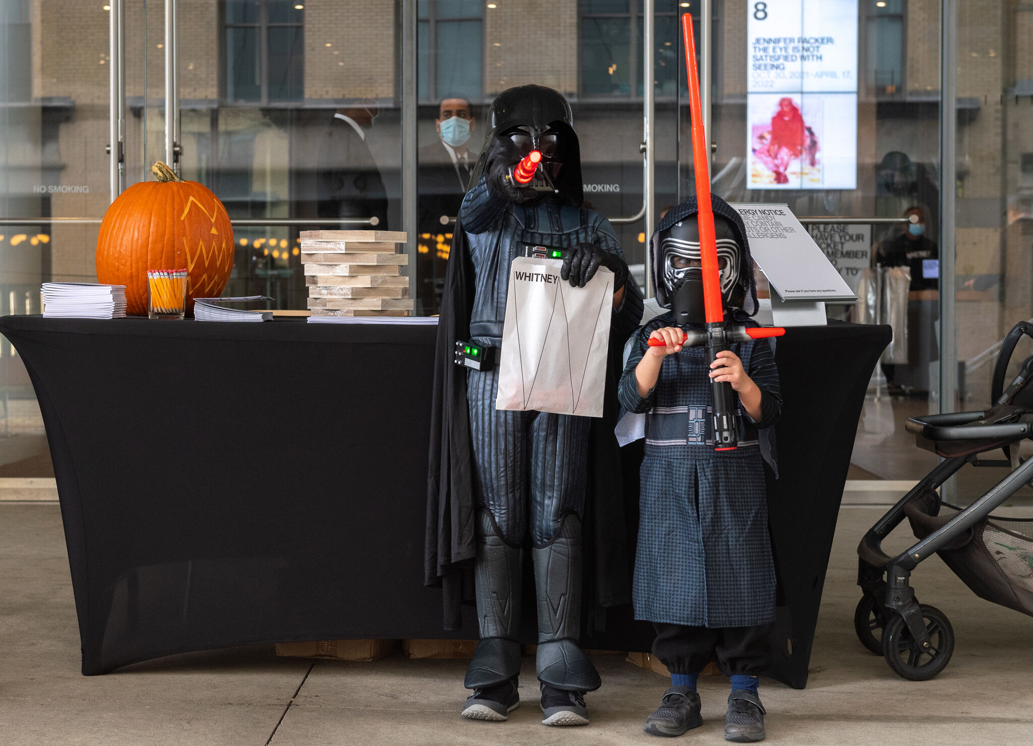 Two children dressed in Star Wars costumes stand in front of the Museum. 