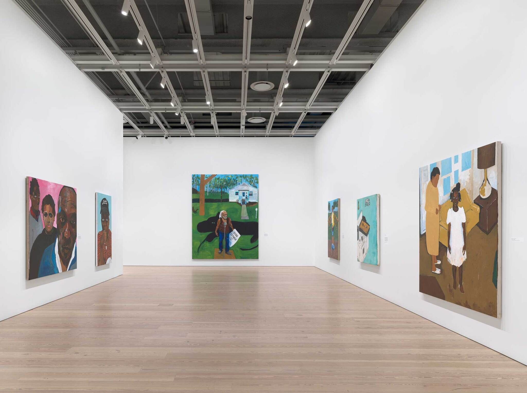 A room with large-scale colorful painted portraits.