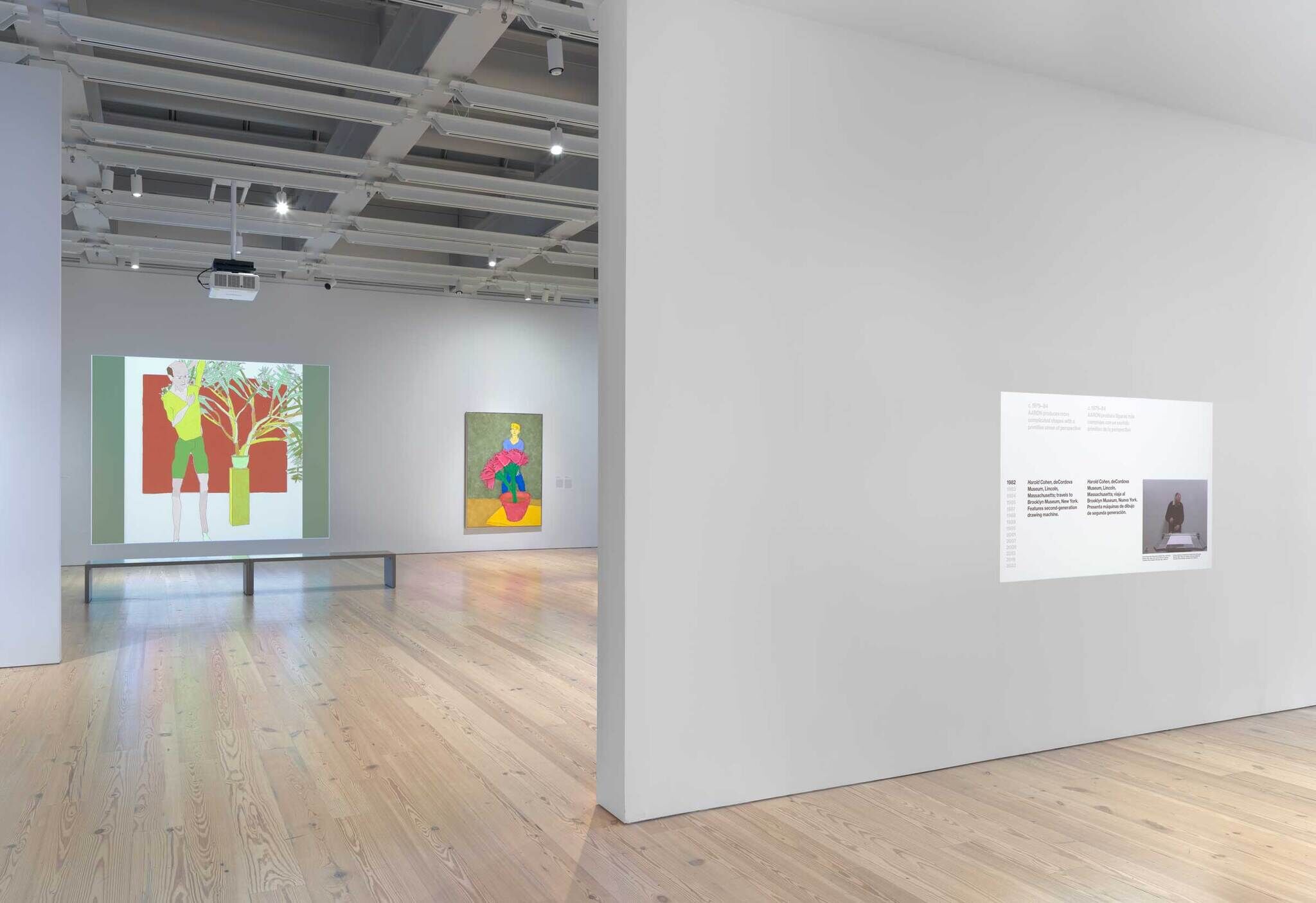 Modern art gallery interior with two colorful paintings on white walls and informational text panels.