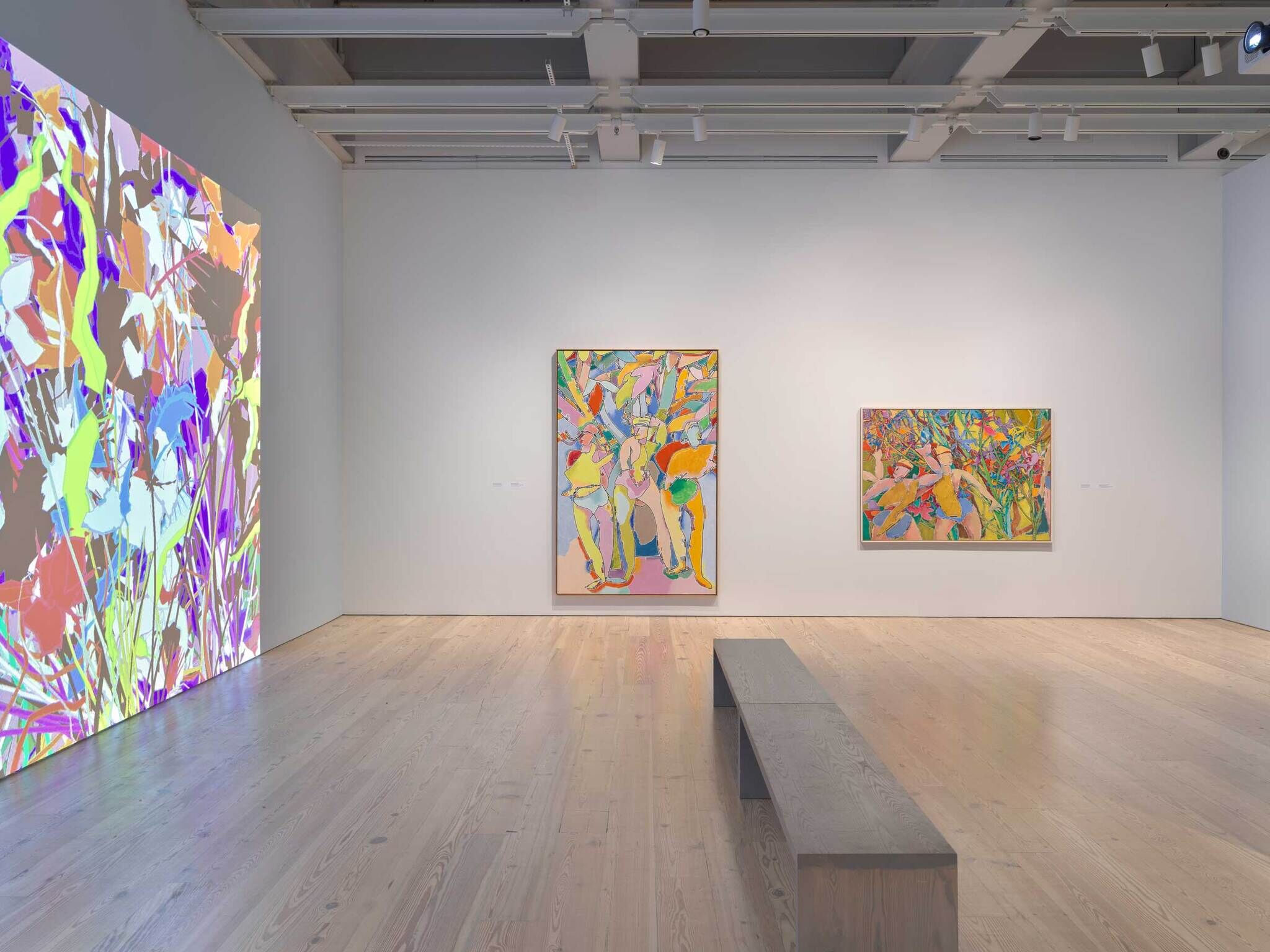 Modern art gallery interior with colorful abstract paintings on white walls and a wooden floor.