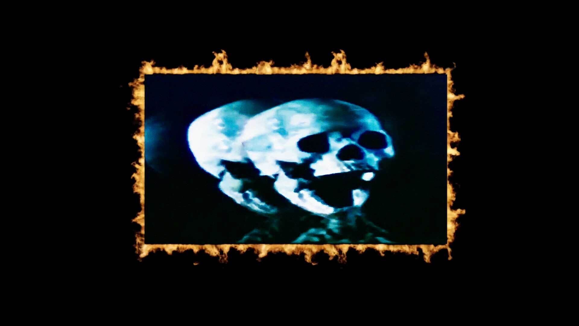 A glowing blue skull against a black background with a burnt edge effect.