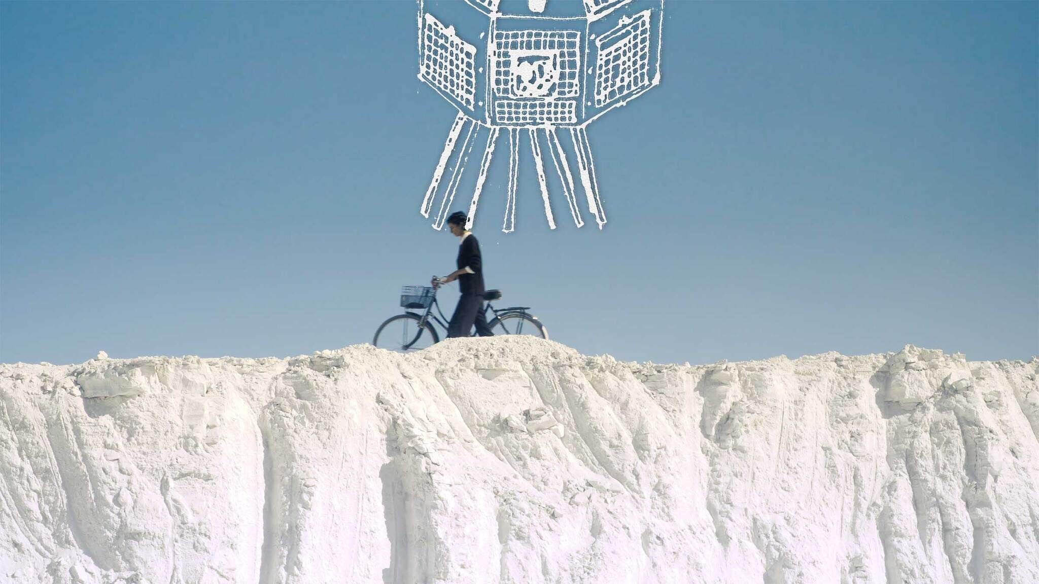 Person cycling on a chalky ridge with a stylized drawing of a satellite overhead against a clear blue sky.