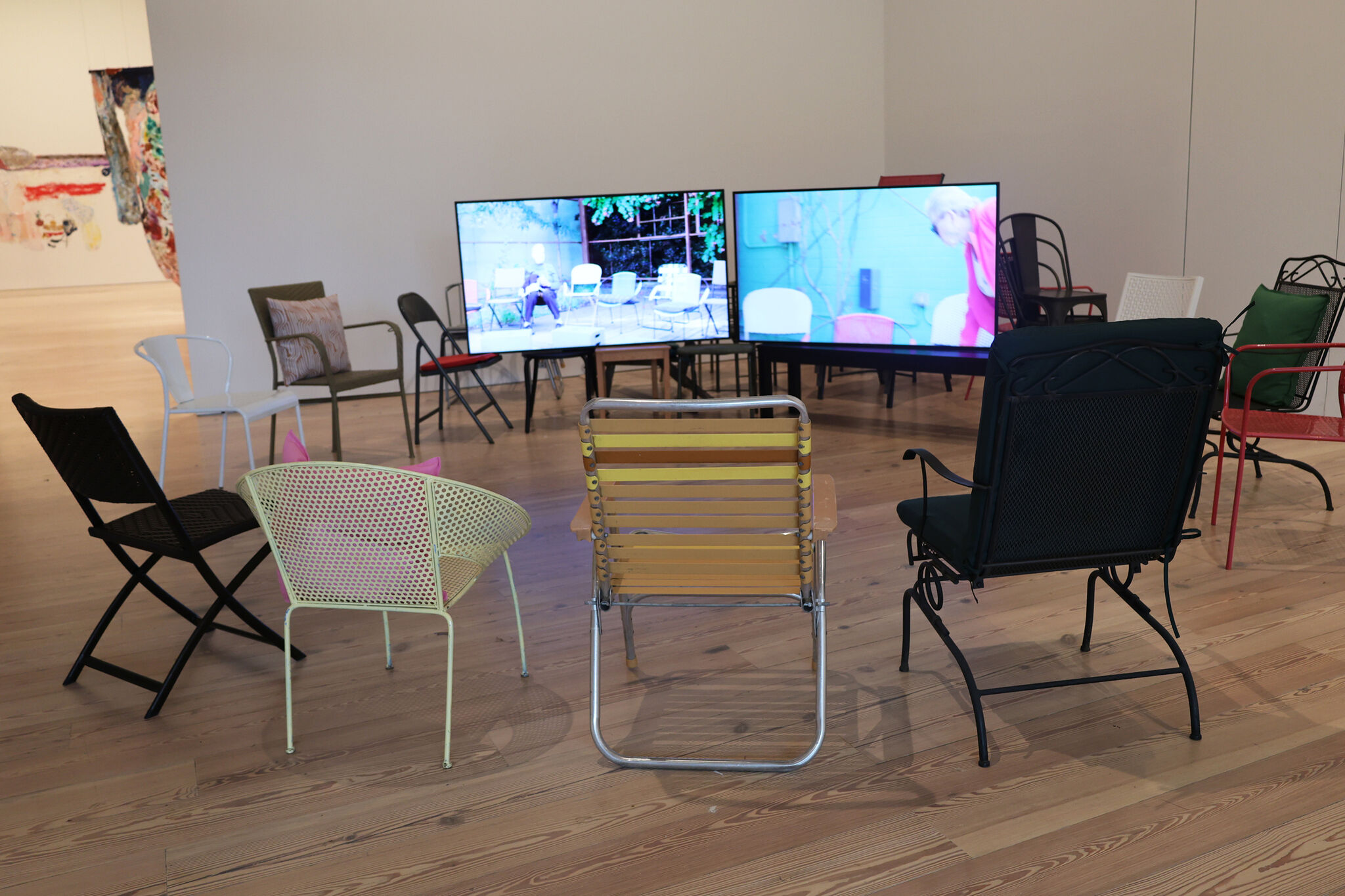 Assorted chairs gathered in a circle around two video screens.