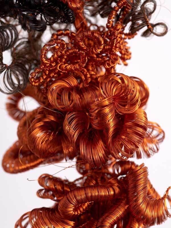 Deep copper red and brown spirals woven together like curls of hair.
