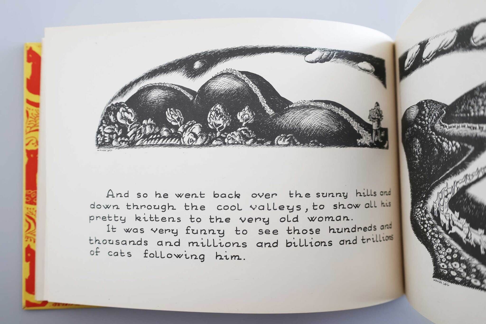 Open book with an illustration of a hill covered in cats and text describing a journey to show kittens to an old woman.