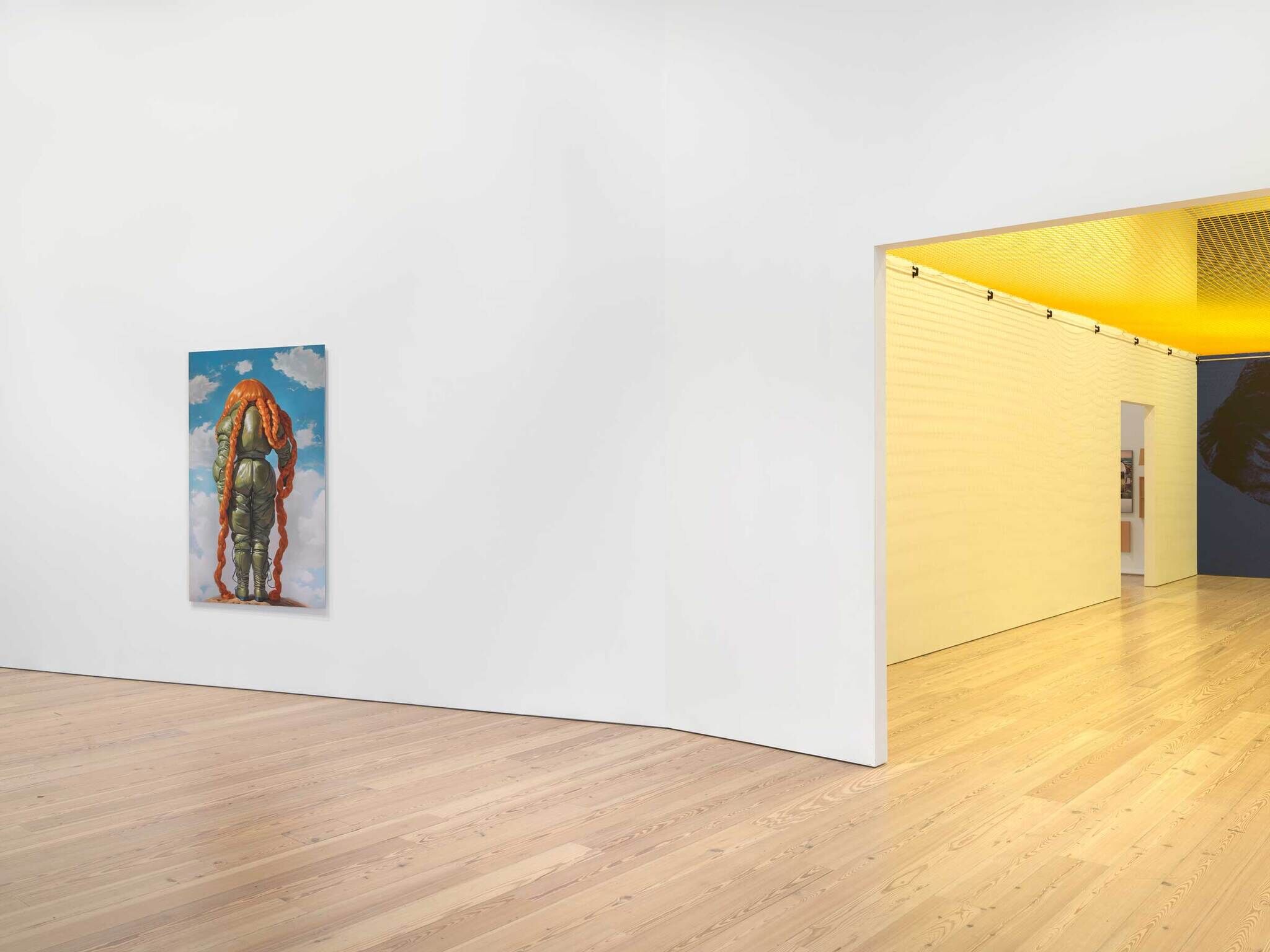 Modern art gallery interior with a single painting on a white wall, wooden floor, and a yellow ceiling in the adjacent room.