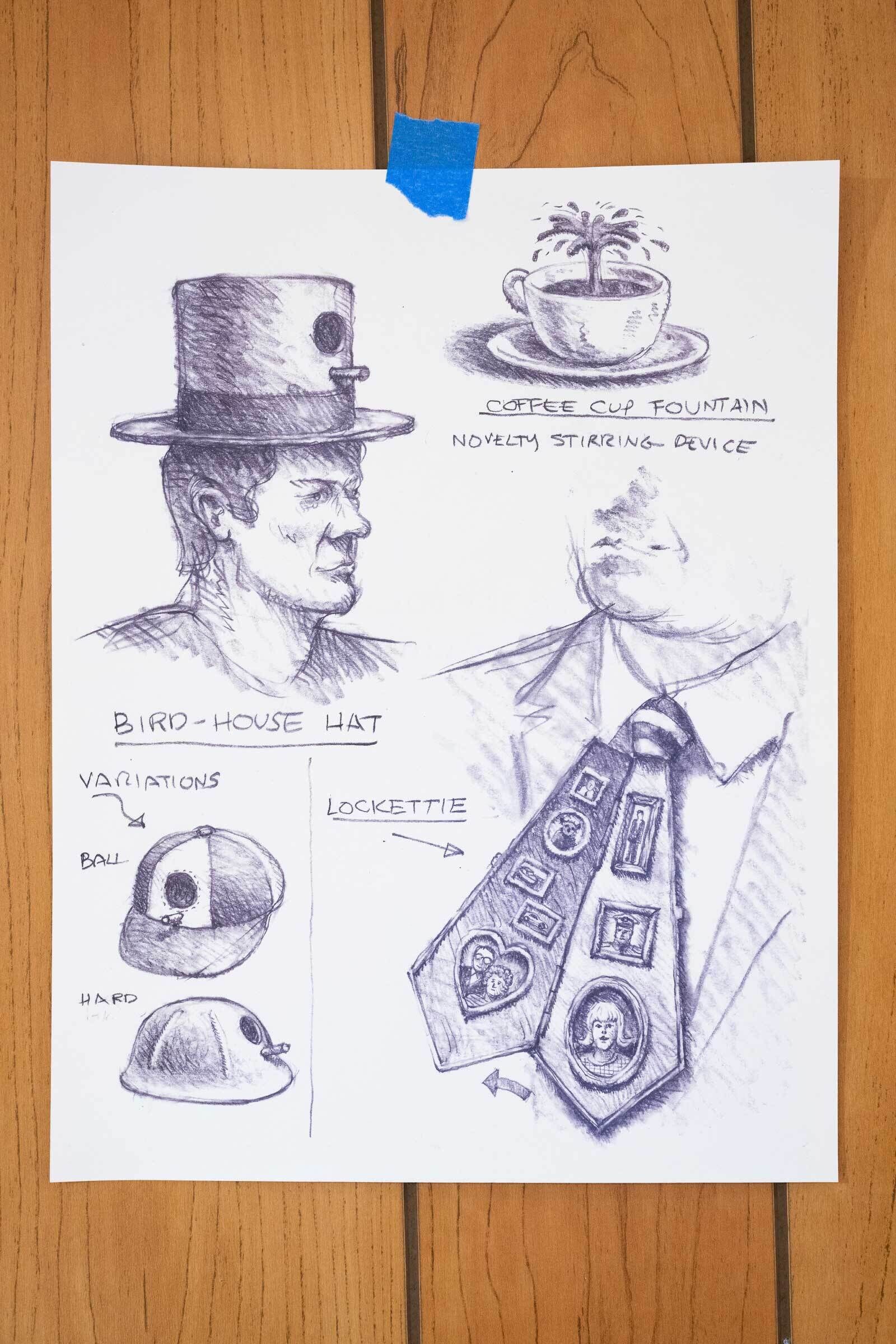 Sketches of whimsical inventions like a top hat with a door, a coffee cup fountain, and a tie with lockets taped to a wooden surface.