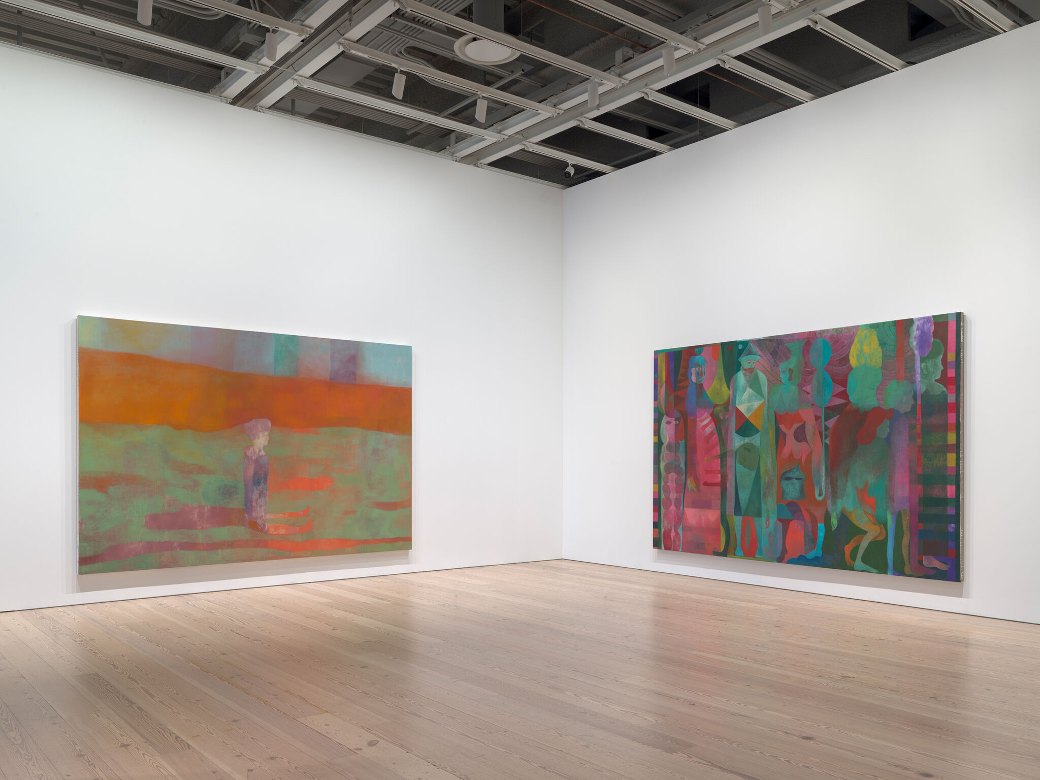 Two large paintings hang on white walls in a modern gallery. The left painting features warm tones, while the right painting has vibrant, multicolored figures.