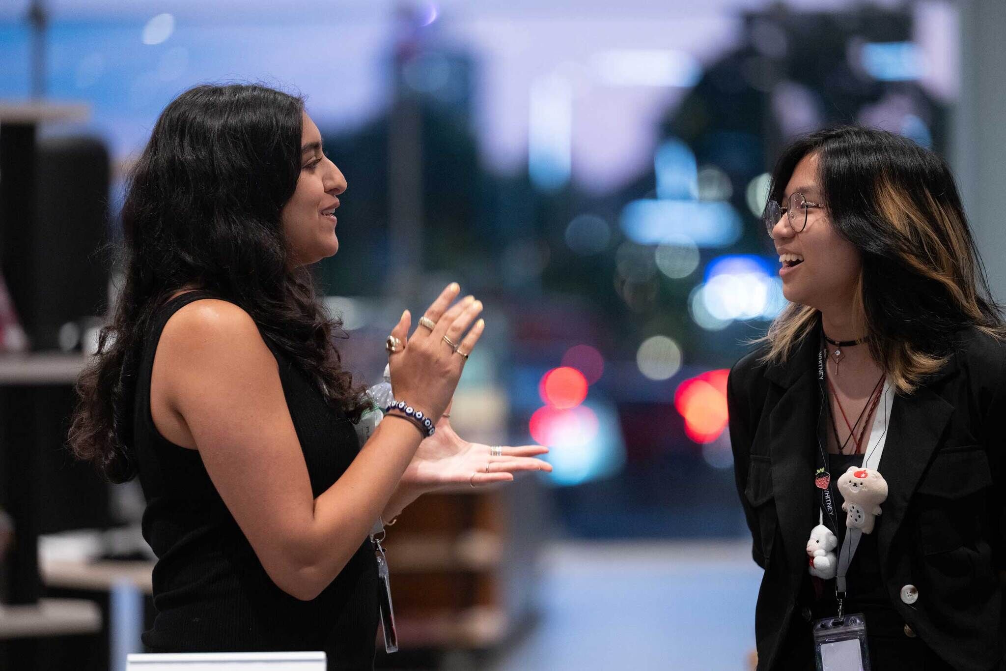 Two youth face each other and smile while in conversation.