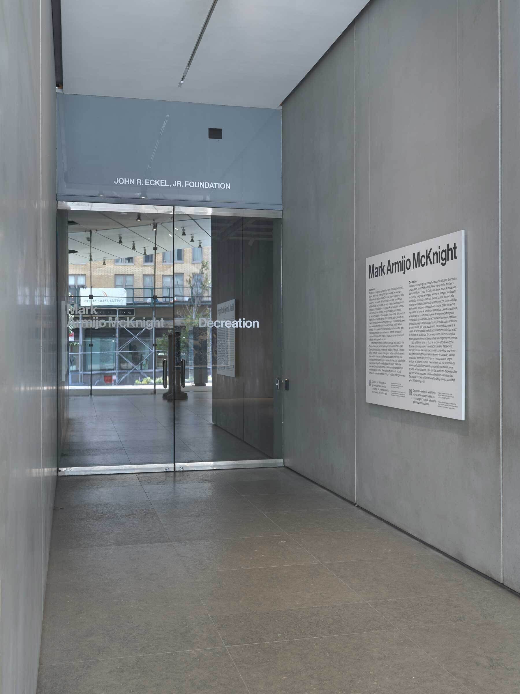 A hallway with a glass door labeled "John R. Eckel, Jr. Foundation" and a wall plaque titled "Mark Armijo McKnight" with text.