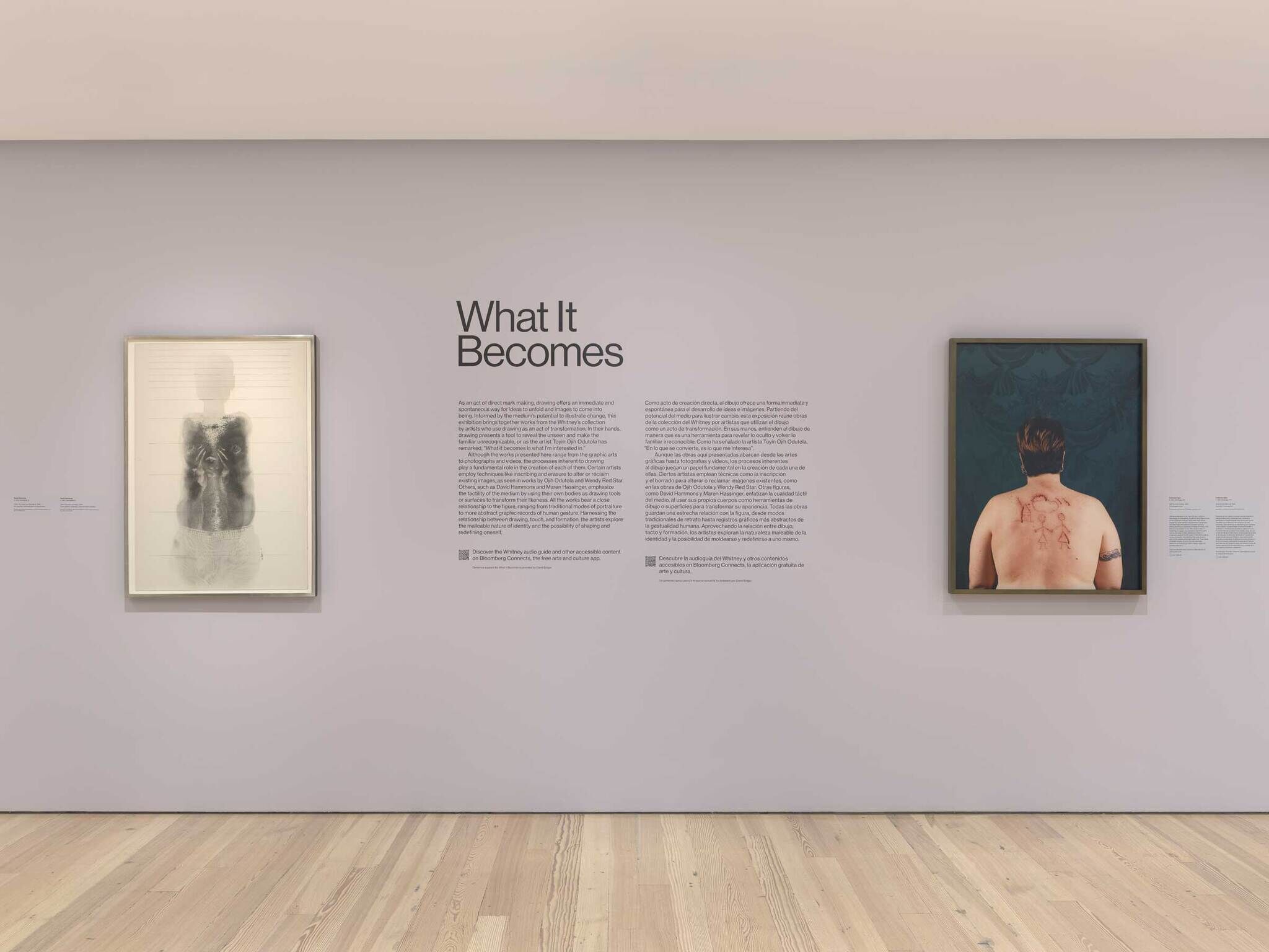 Art gallery wall with two framed artworks and text titled "What It Becomes" in the center. Left: abstract figure. Right: person with back etchings.