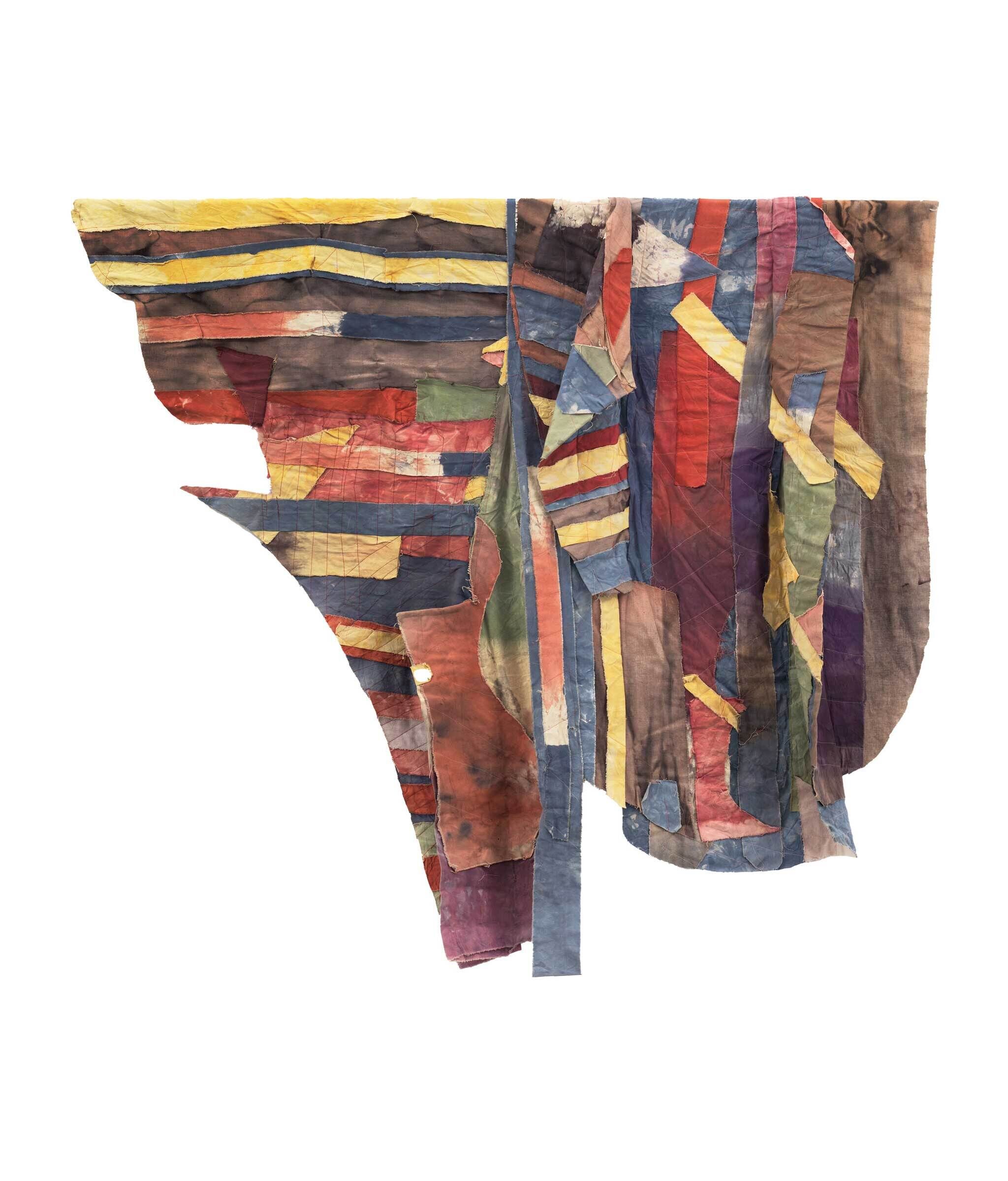 Abstract textile art with multicolored, irregularly shaped fabric pieces stitched together, featuring stripes and patches in various hues.