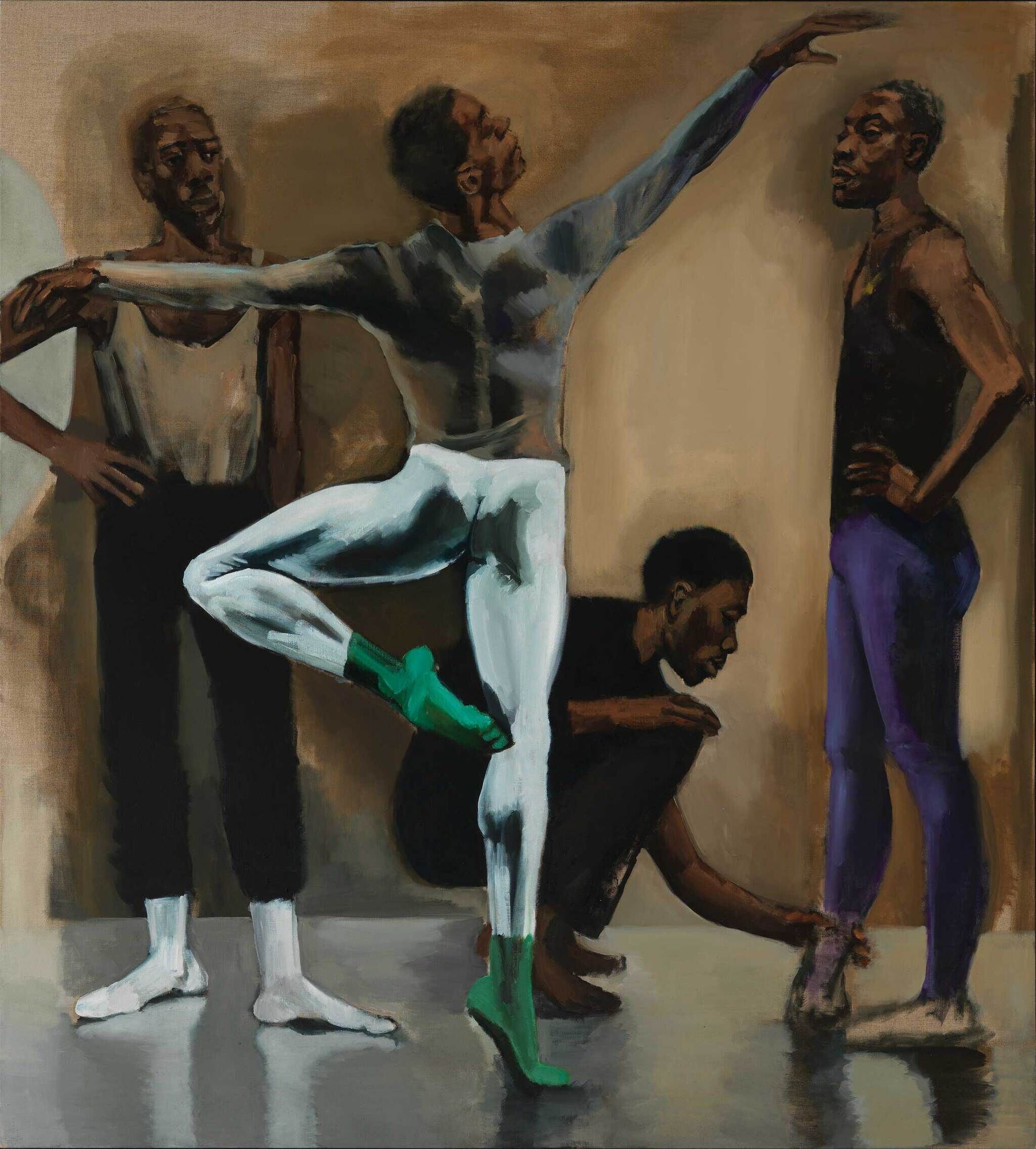 Four dancers in a studio, one in a pose with green socks, another adjusting a shoe, and two others standing and observing.