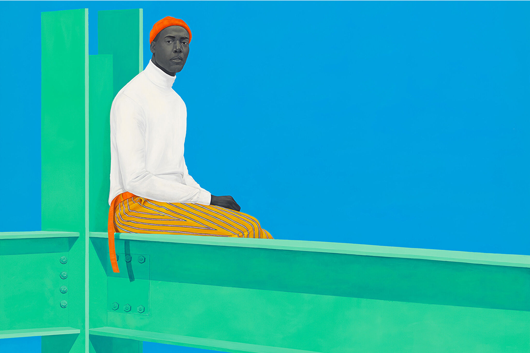 Man in bright orange beanie, complimenting orange striped pants, and a white turtleneck sits at the bracket of a steel beam painted green against a bright blue background.
