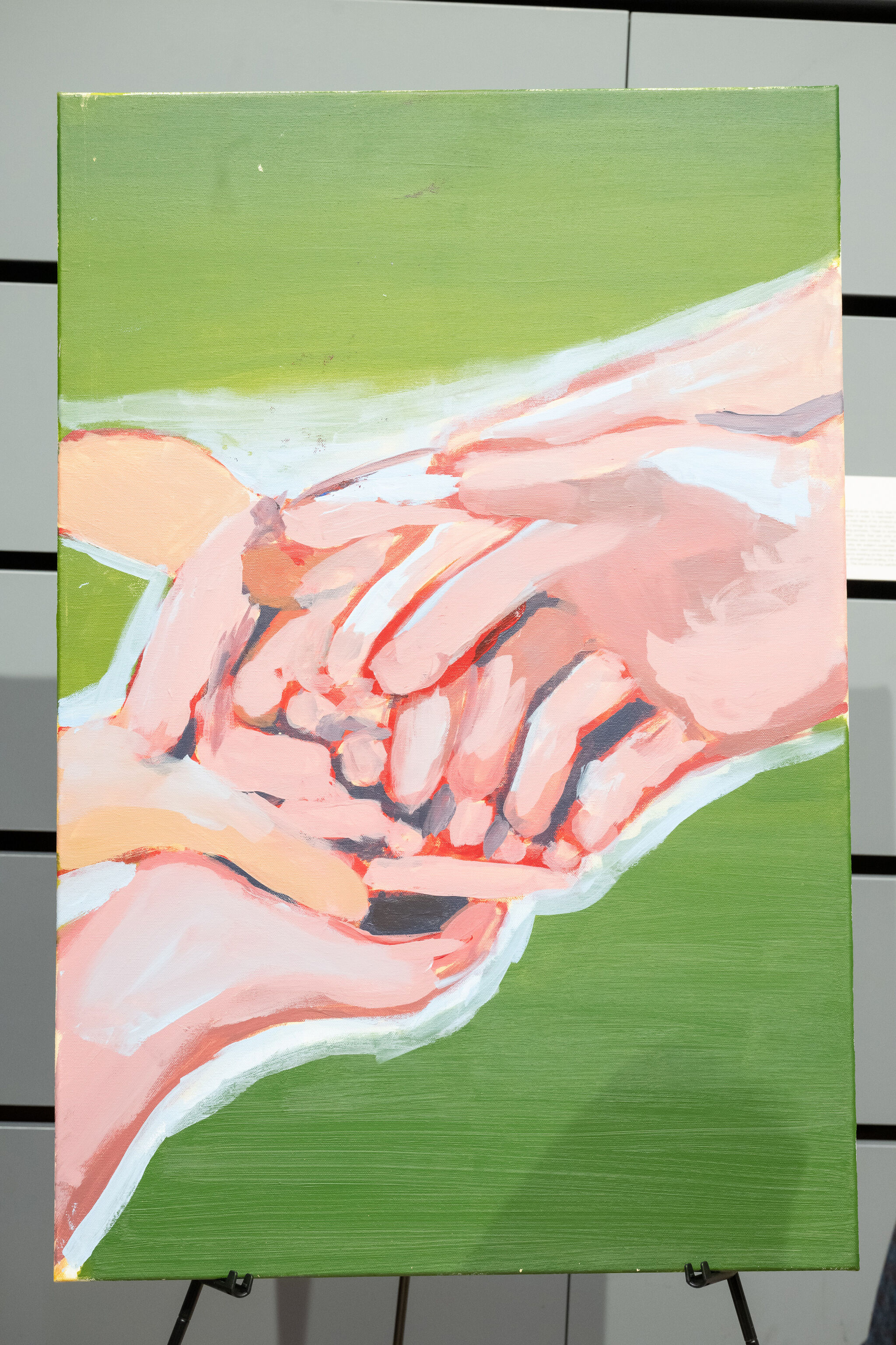 Painting of two hands gently holding a small animal, set against a green background.