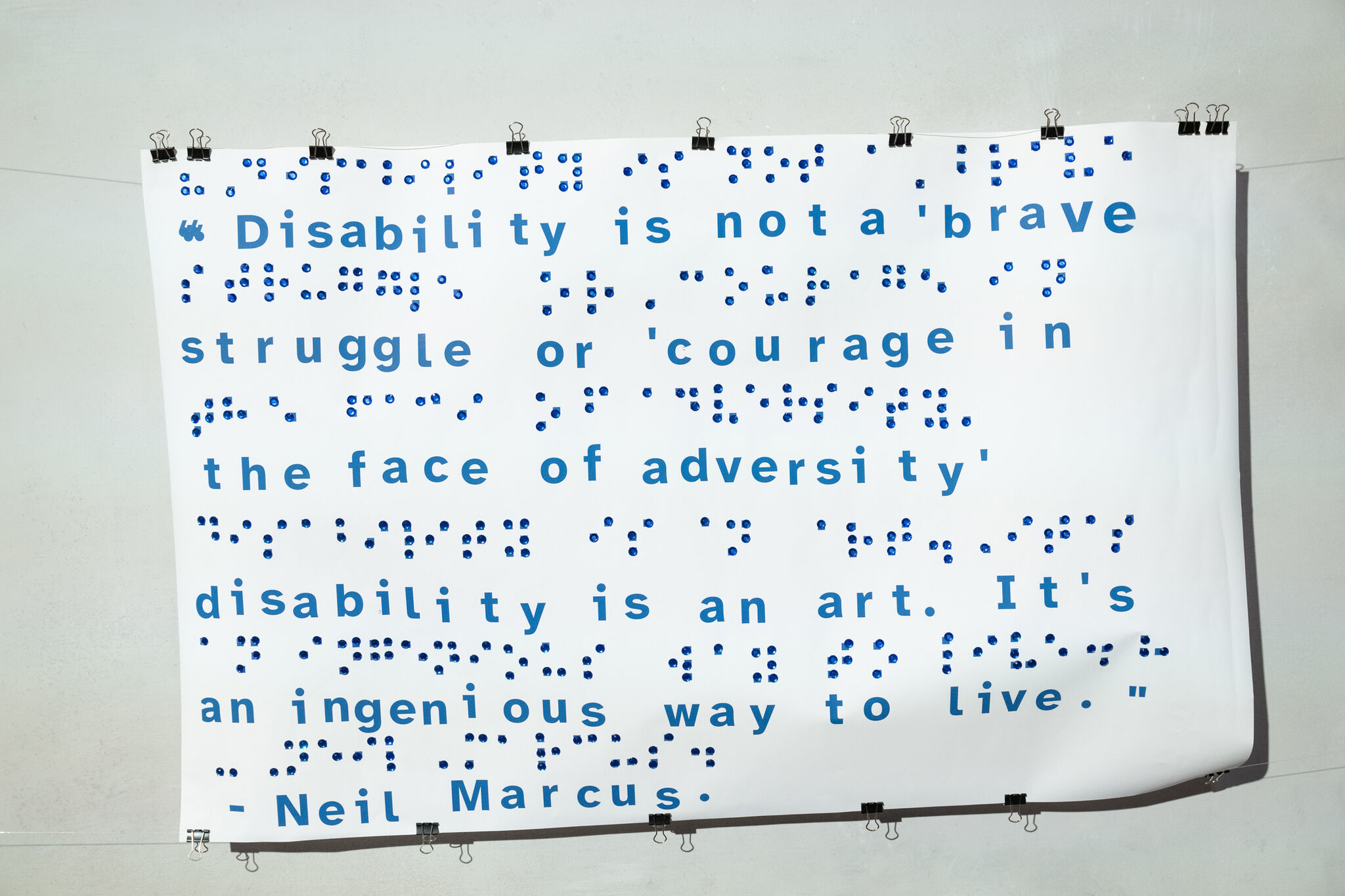 Poster with text and Braille: "Disability is not a 'brave struggle'... it's an ingenious way to live." - Neil Marcus.