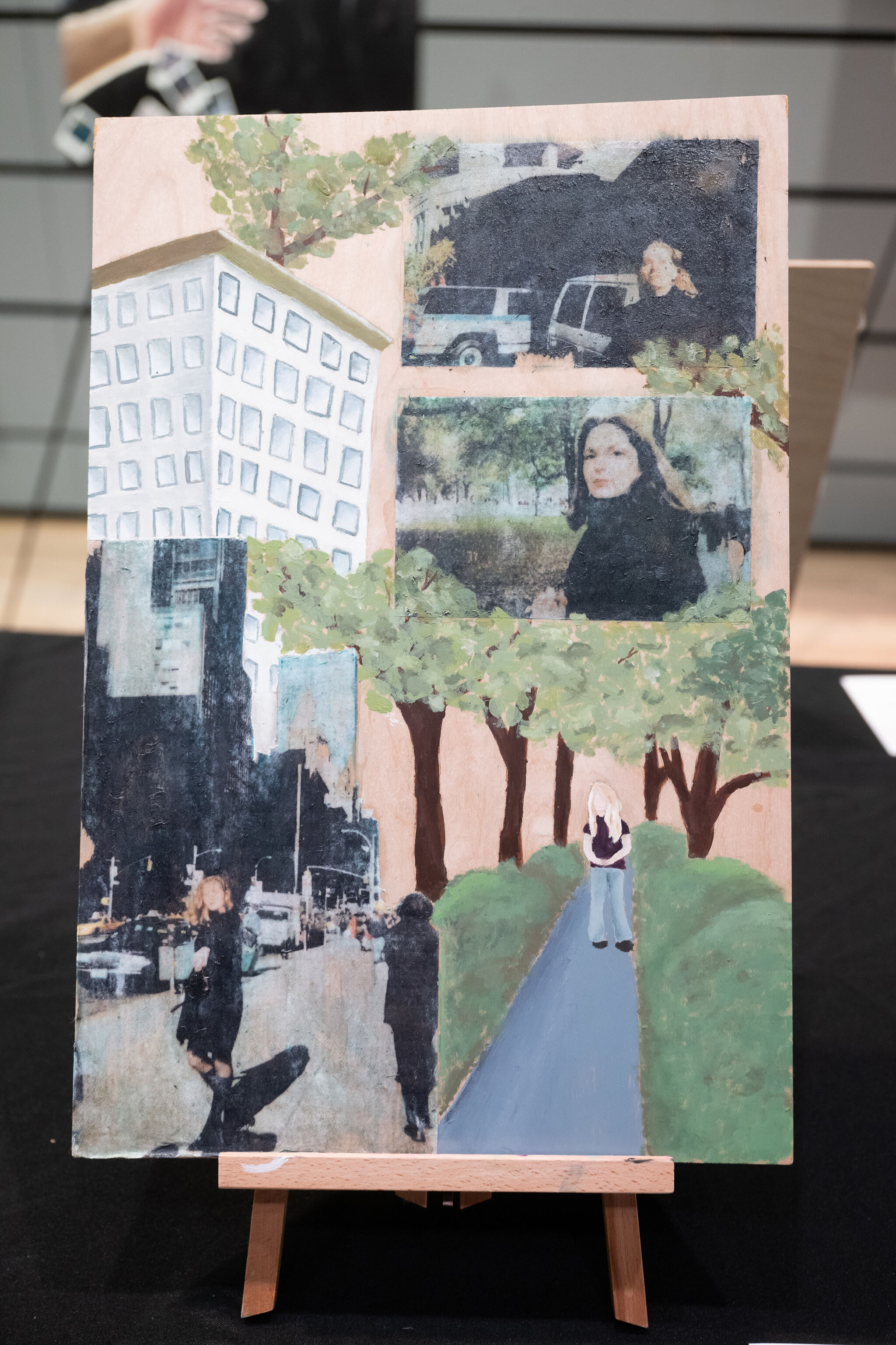 Collage artwork on an easel featuring urban scenes, trees, and people in various settings, blending photography and painting.