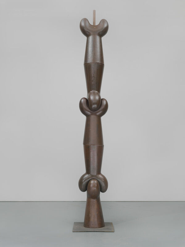 Tall, abstract bronze sculpture with three stacked, rounded forms, each featuring curved shapes and smooth surfaces.