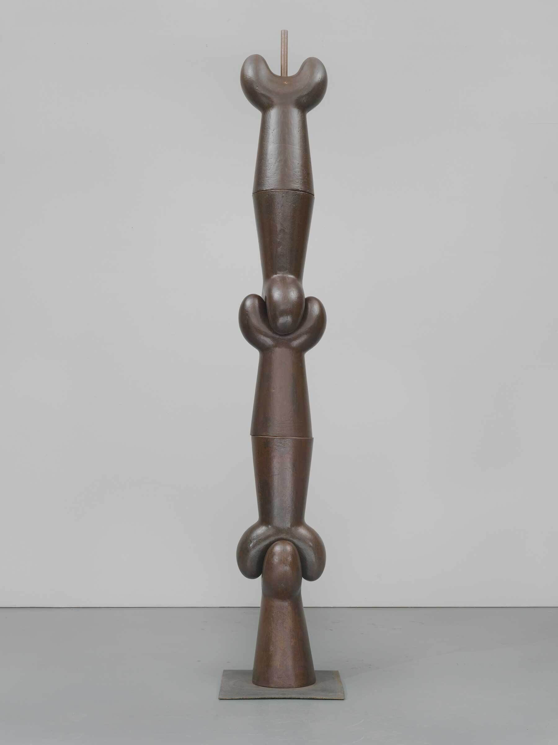 Tall bronze sculpture with three stacked abstract shapes, each featuring rounded forms and smooth surfaces, standing on a square base.